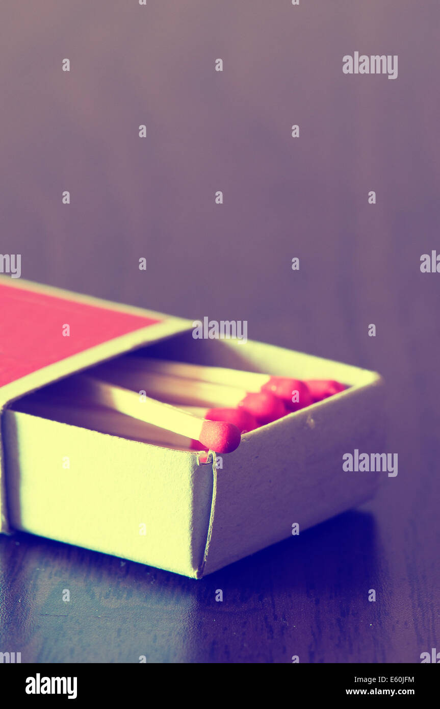 Matchbox piena di corrispondenze di colore rosso sul tavolo Foto Stock