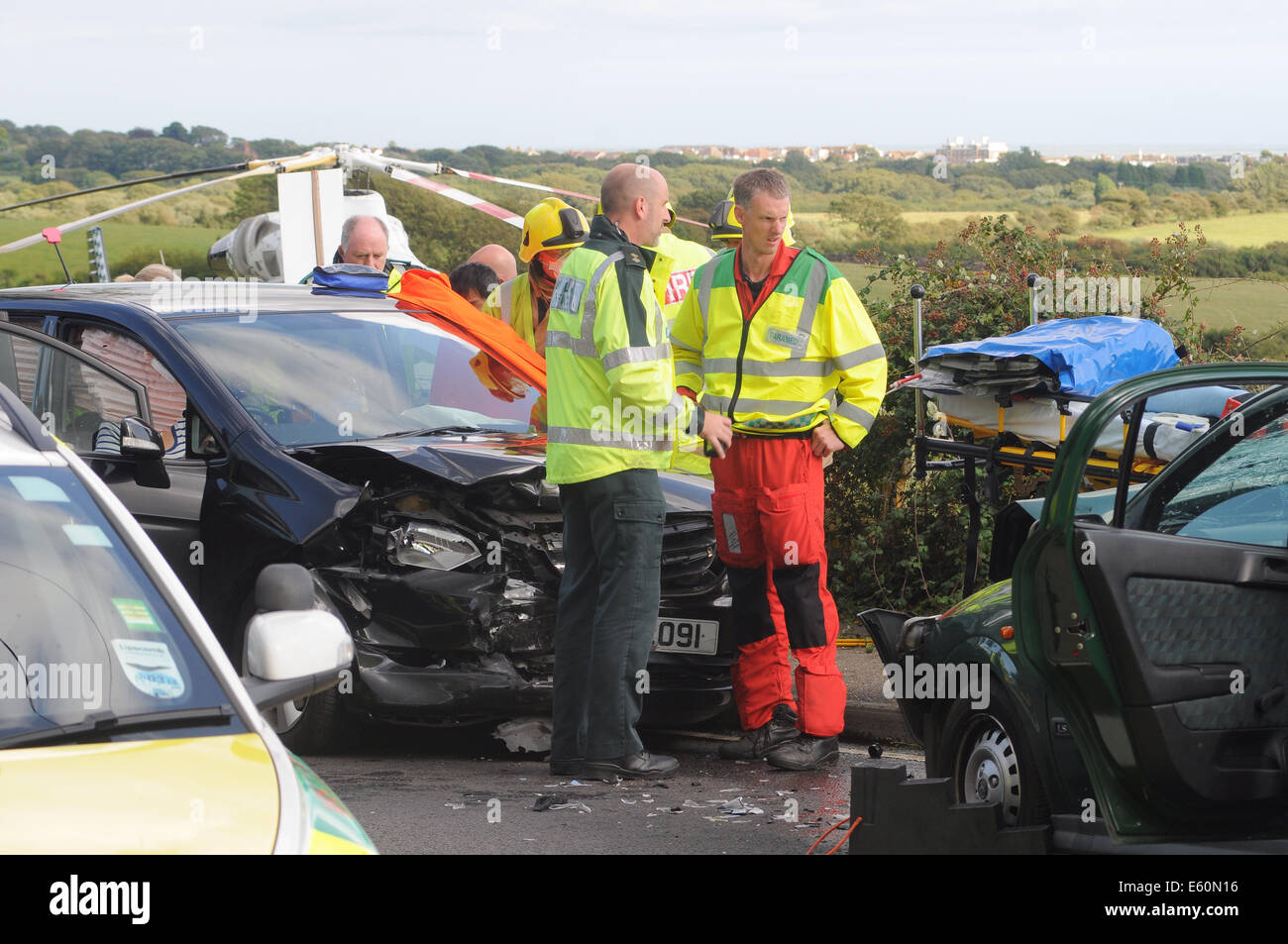 Bexhill, East Sussex, Regno Unito.10 agosto 2014. I servizi di emergenza in azione dopo un incidente stradale sulla A259 , Barnhorn Road, West di poco comune. Una signora è stata presa dalla scena di strada ambulanza polizia ha informato le ferite non erano gravi, evacuazione in elicottero non è stato richiesto da Kent orli che fu rapidamente sul sito. La gente del posto in corrispondenza della scena avvertire che questo è un normale incidente nero posto.. David Burr/Alamy Live News Foto Stock