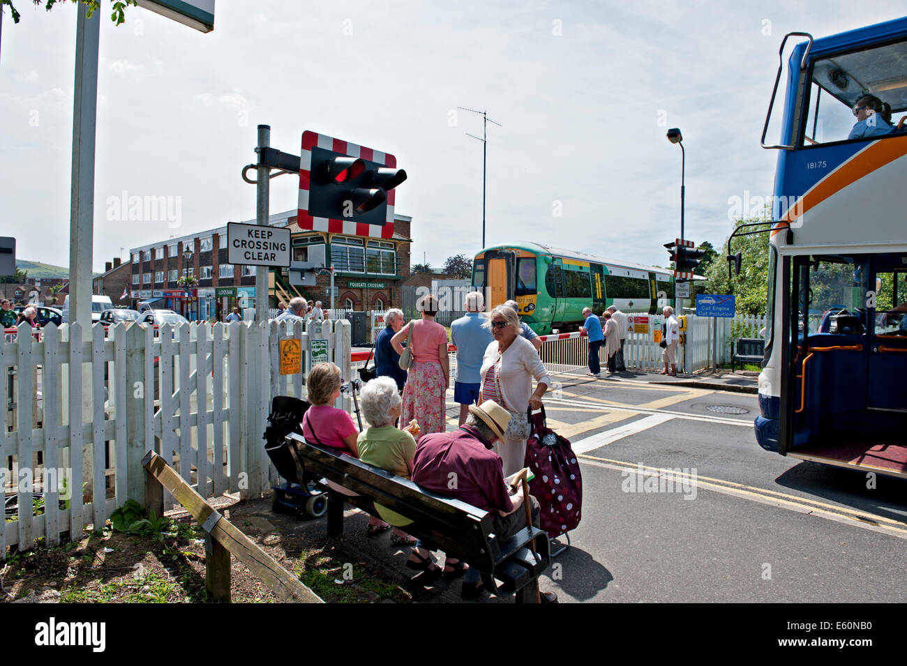 Pedoni e traffico di attendere presso l'incrocio ferroviario a Polegate Sussex. Regno Unito Foto Stock