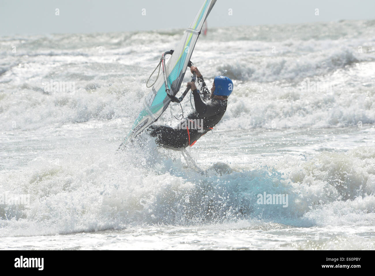 Windsurf su un selvaggio e giornata di vento a West Wittering Beach, Nr. Chichester, West Sussex, in Inghilterra, Regno Unito Foto Stock