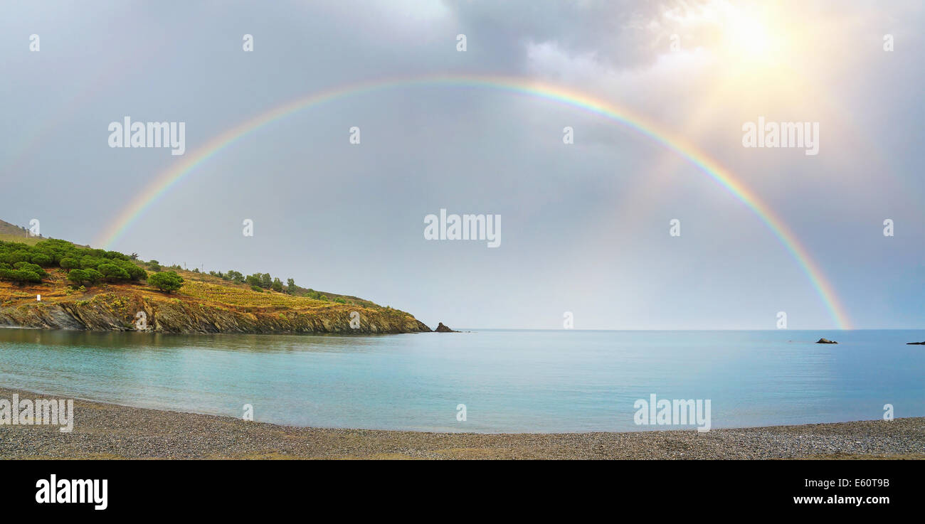 Panorama di un arcobaleno, metà oltre la terra e il mare nella baia del Mediterraneo di Paulilles, Rossiglione e Pirenei Orientali, Francia Foto Stock