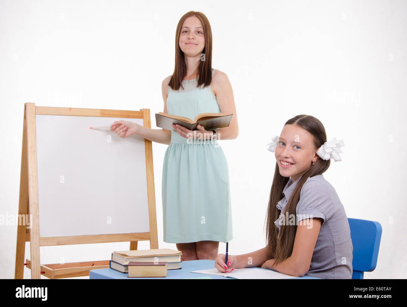 L insegnante si erge a lavagna, uno studente seduto alla scrivania e ascoltando il Maestro Foto Stock