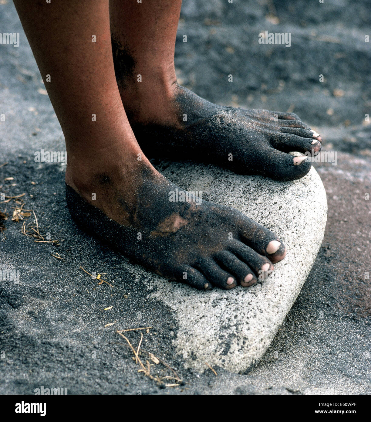 Sticky sabbia nera copre i piedi di un beachgoer in Montserrat, una piccola isola vulcanica nel Mar dei Caraibi che è un cittadino britannico di territorio d'oltremare. Foto Stock