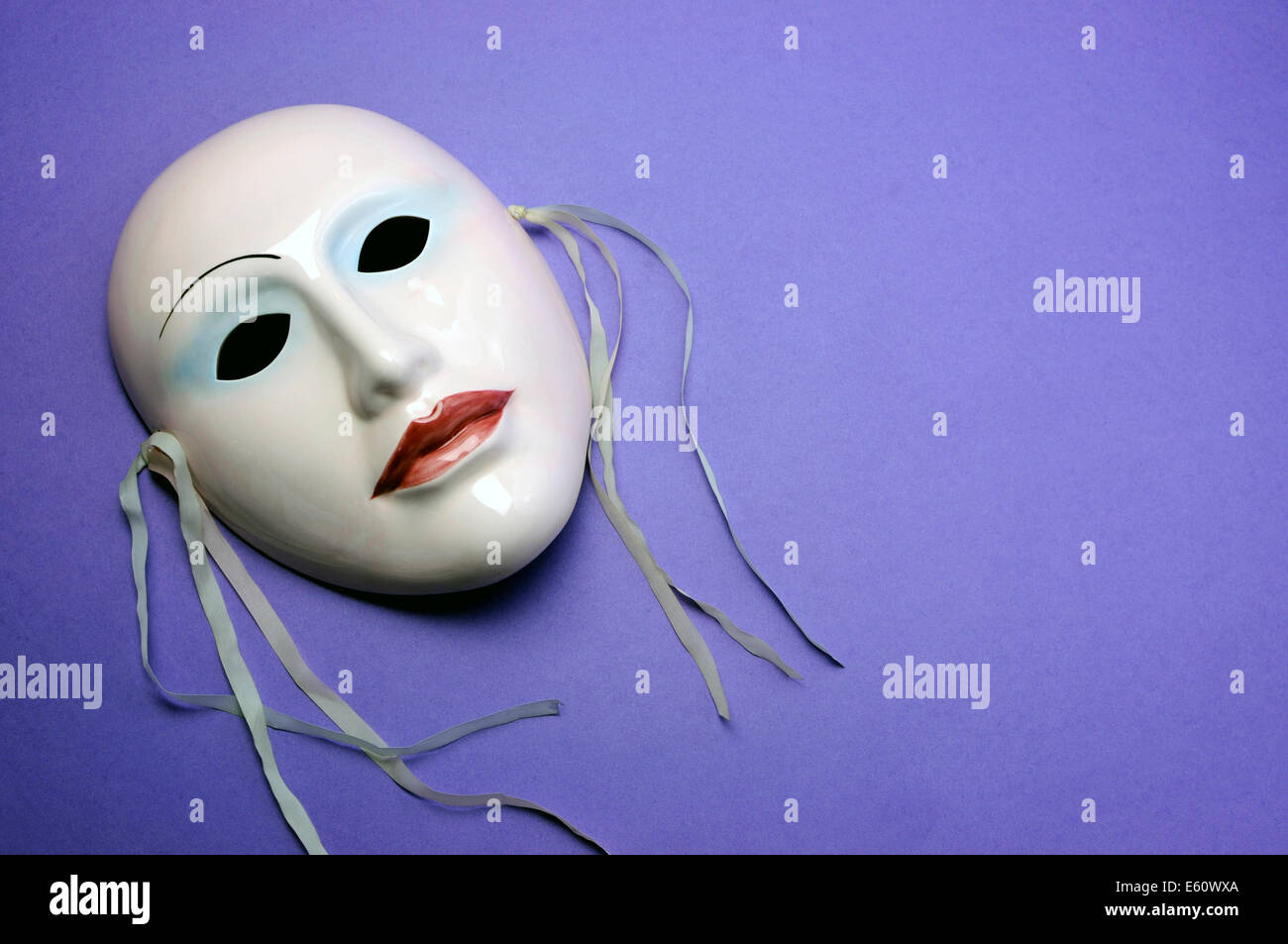 Rosa pallido Maschera in ceramica su sfondo viola per attore, prestazioni o il concetto di teatro con copia spazio per il testo qui. Foto Stock