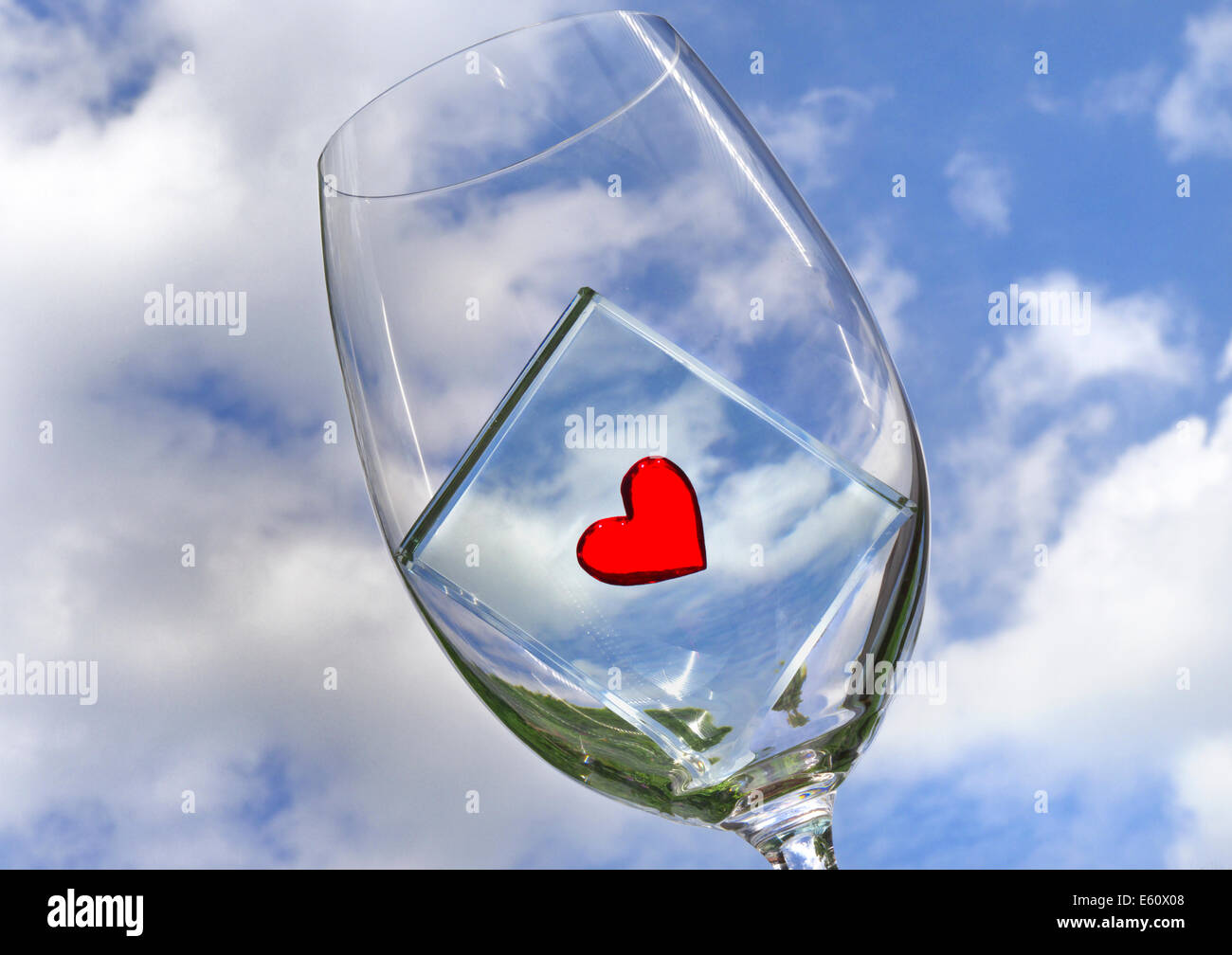 Immagine concettuale del bicchiere da vino con cuore motivo con cielo blu dietro Foto Stock