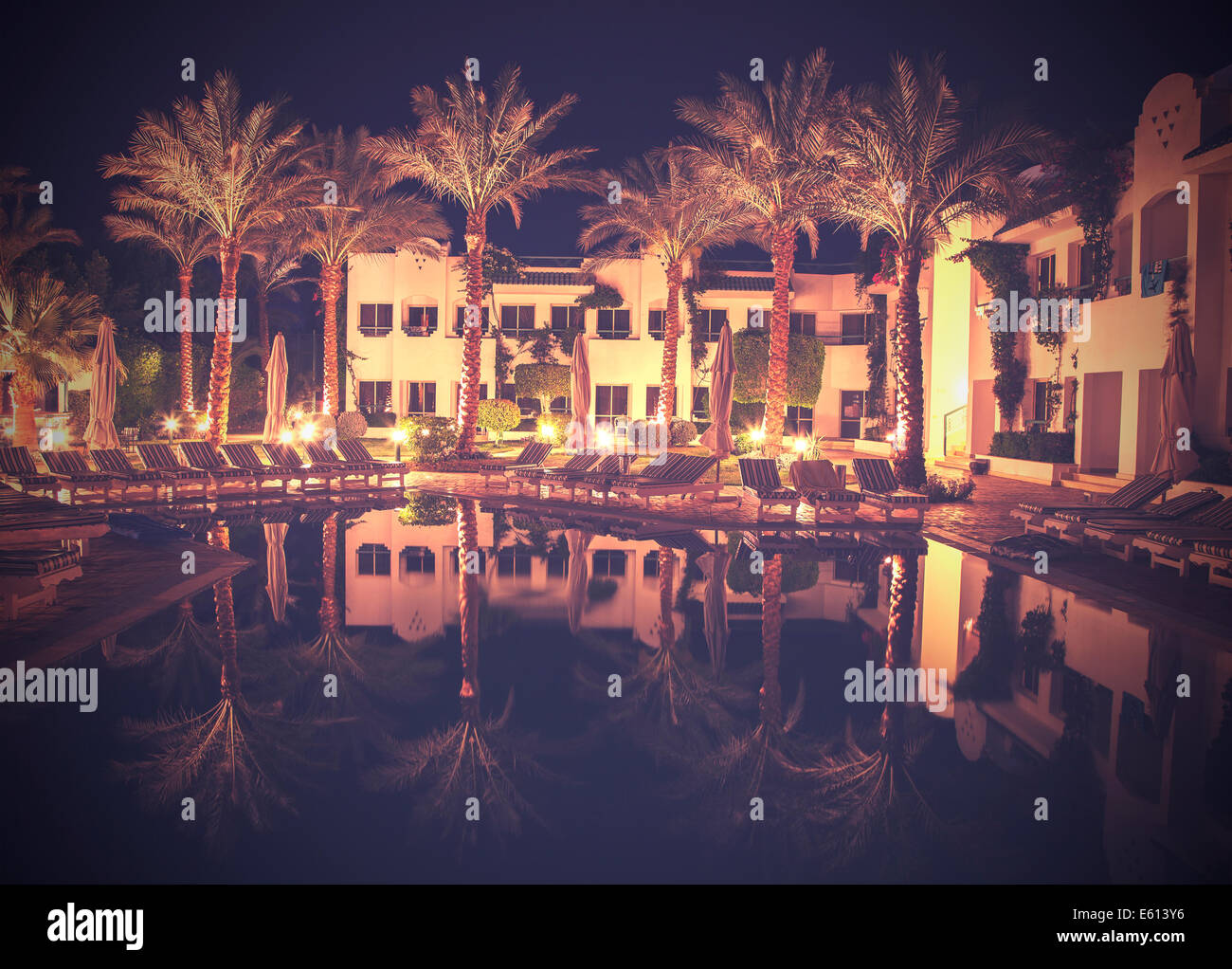 Retrò stile vintage foto del lato piscina dell'hotel di notte. Foto Stock