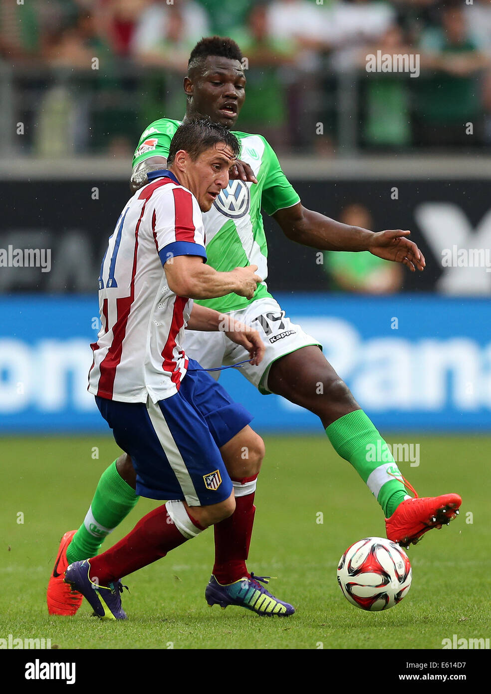 Wolfsburg del Junior Malanda (R) gioca contro Madrid Rodriguez cristiana durante il soccer test match VfL Wolfsburg vs Atletico Madrid a Volkswagenarena a Wolfsburg, in Germania, il 10 agosto 2014. Foto: Ronny Hartmann/dpa Foto Stock