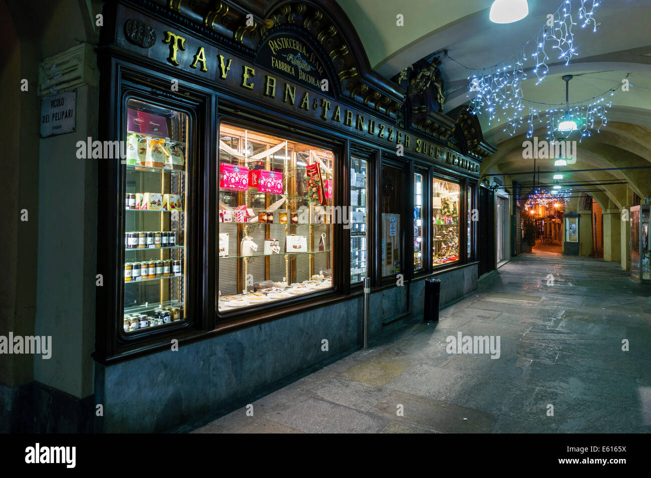 Vetrina di una pasticceria, pasticceria e bar, sotto i portici di Piazza Cavour, di notte, Vercelli Piemonte, Italia Foto Stock