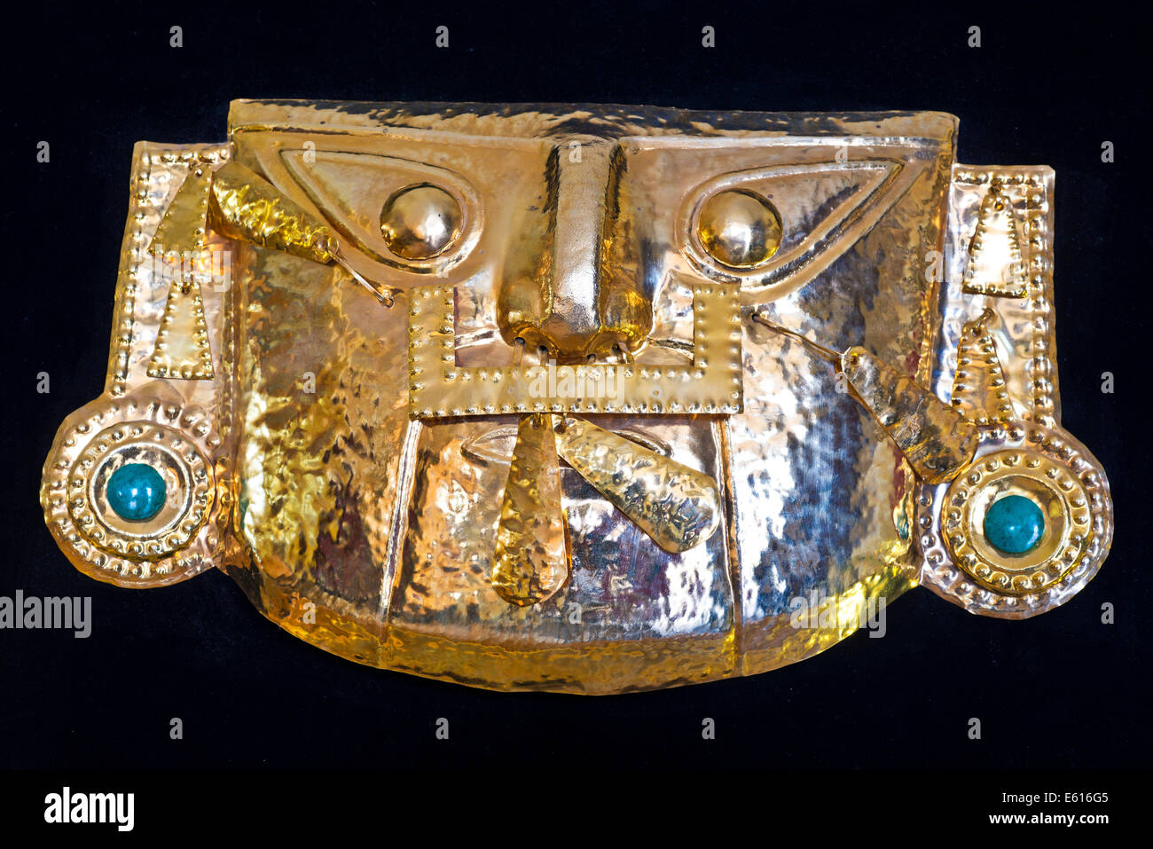 Golden pre-colombiana maschera Inca, replica, foglio ottone con pietre semi-preziose, souvenir, Cusco, Perù Foto Stock