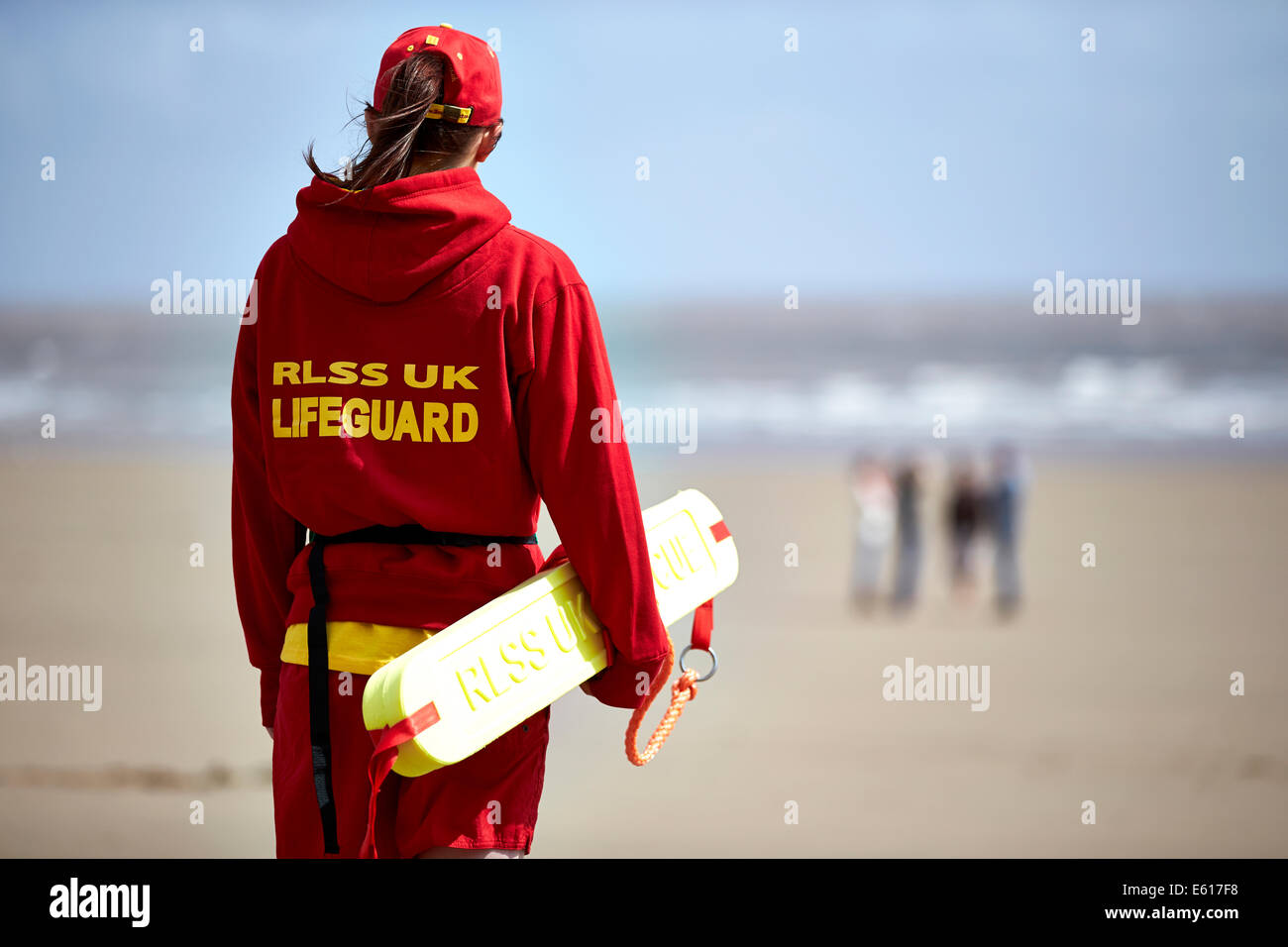 Un RLSS o Royal Life saving life guard sta guardare vicino al mare sulla spiaggia. Vita delle guardie prevenire annegamento nell'acqua. Foto Stock