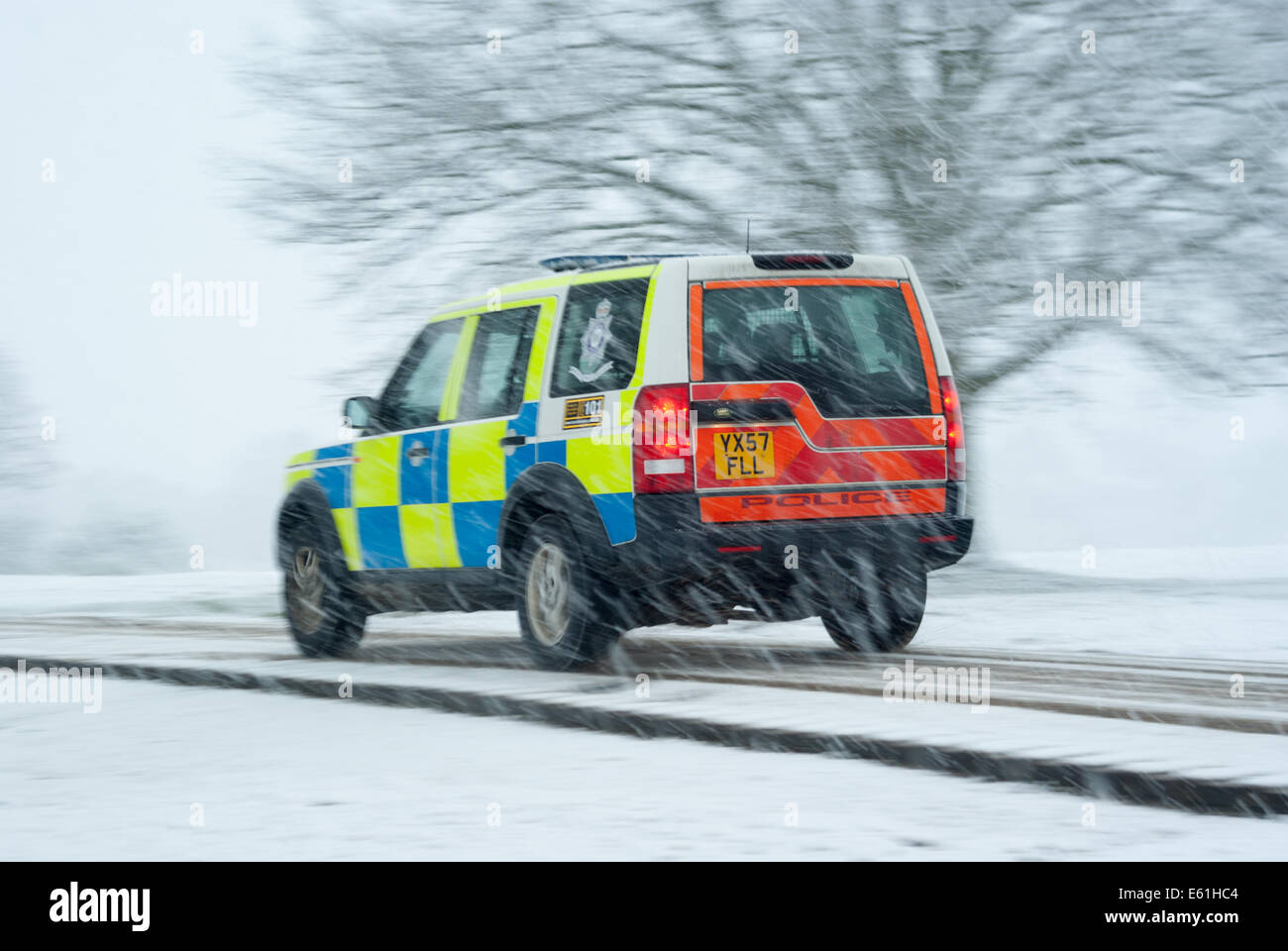 Un altamente visibile la polizia Land Rover Discovery 4x4 la guida su una strada innevata in condizioni pericolose Foto Stock