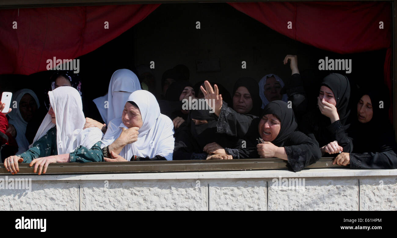 Nablus, West Bank, Territorio palestinese. 11 Ago, 2014. Parenti palestinese del corpo di Zakariah al-Aqrah, 21, piangono durante il suo funerale in Cisgiordania villaggio di Qabalan vicino a Nablus, Lunedì 11 Agosto, 2014. Al-Aqra è stato ucciso lunedì in una sparatoria con le forze israeliane dopo arresto resistente e foratura in un edificio in un villaggio a sud di Nablus, i media locali hanno riferito Credito: Nedal Eshtayah APA/images/ZUMA filo/Alamy Live News Foto Stock