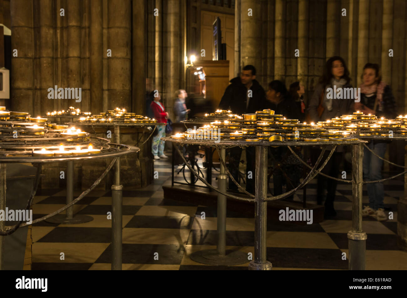 I turisti per i visitatori in cerca di candele accese all'interno della cattedrale di Notre Dame a Parigi, Francia Foto Stock