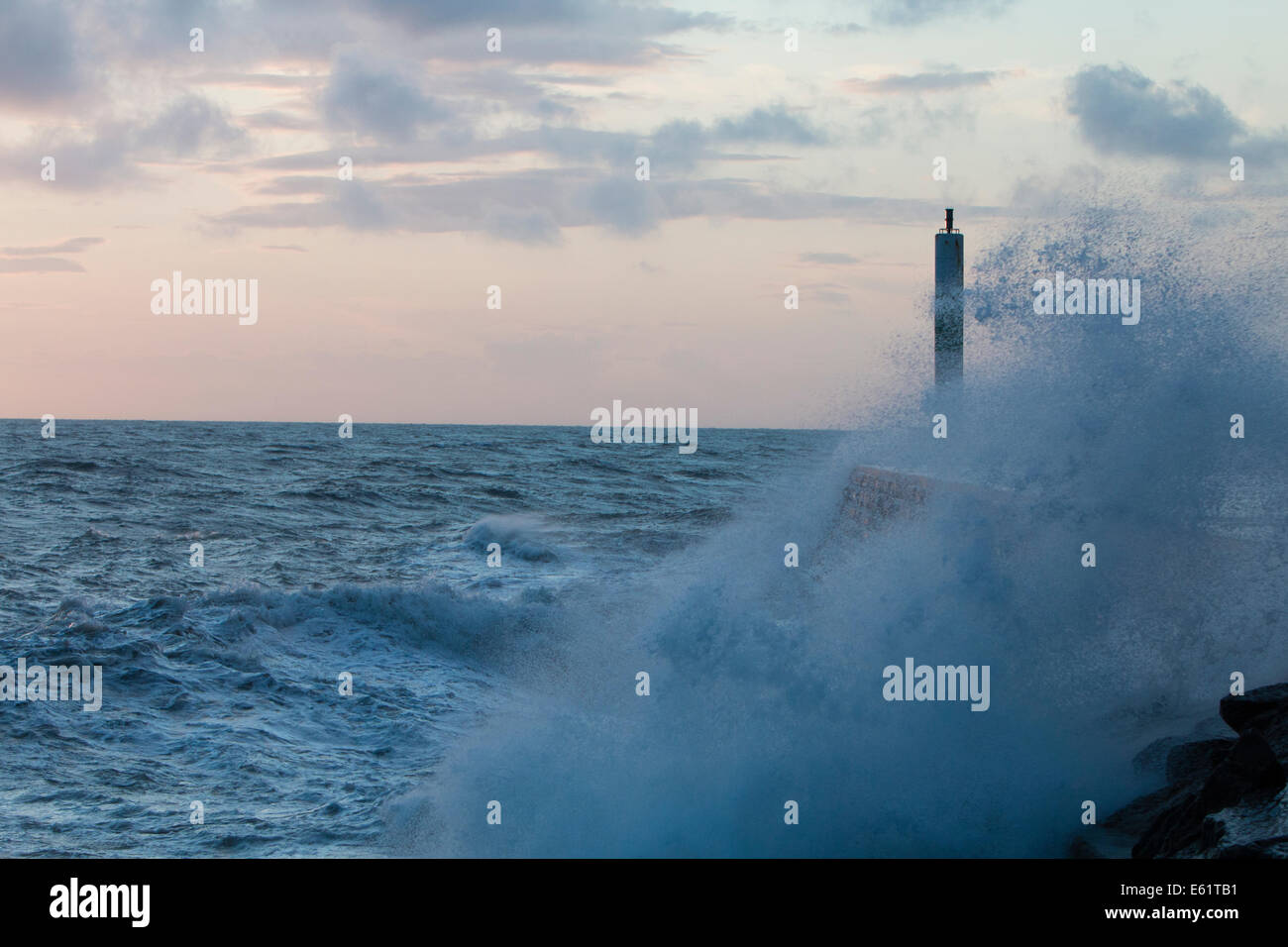 Aberystwyth, Wales, Regno Unito. 11 Ago, 2014. Il mare agitato dalla tempesta chiamato Bertha onde si blocca contro il faro in Aberystwyth al tramonto. Credito: Jon Freeman/Alamy Live News Foto Stock