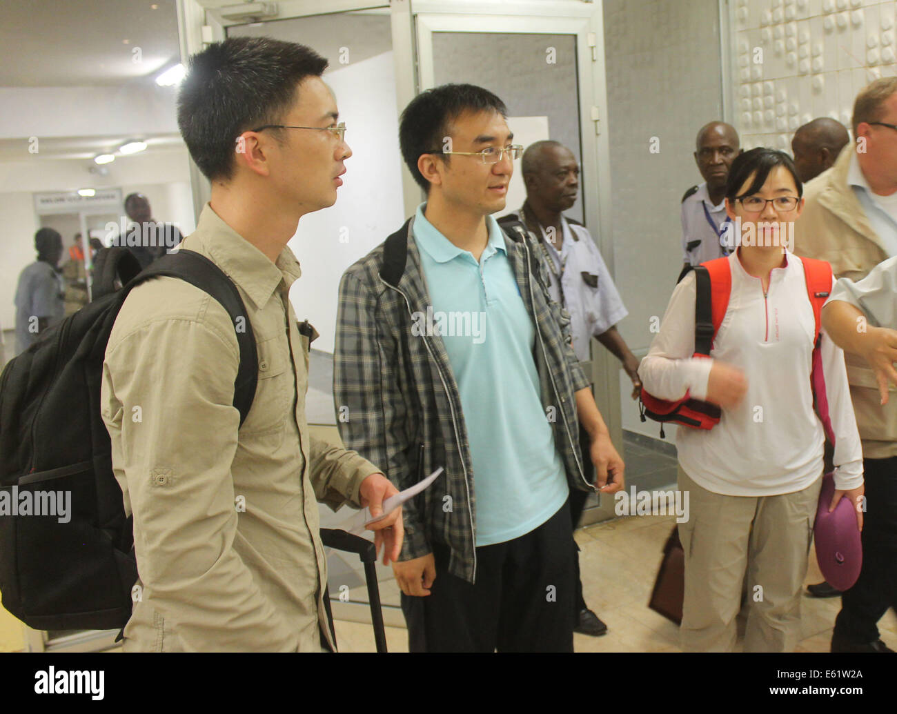 Conakry. 11 Ago, 2014. Tre malattie cinese esperti di controllo arrivano all'aeroporto di Conakry, capitale della Guinea, 11 Agosto, 2014. Il Servizio Sanitario Nazionale e la pianificazione familiare Commissione (NHFPC) ha annunciato il Sabato che la Cina avrebbe inviato tre squadre di esperti e di forniture mediche per la Guinea, la Liberia e la Sierra Leone per aiutare la prevenzione e il controllo del virus Ebola. Credito: Xinhua/Alamy Live News Foto Stock