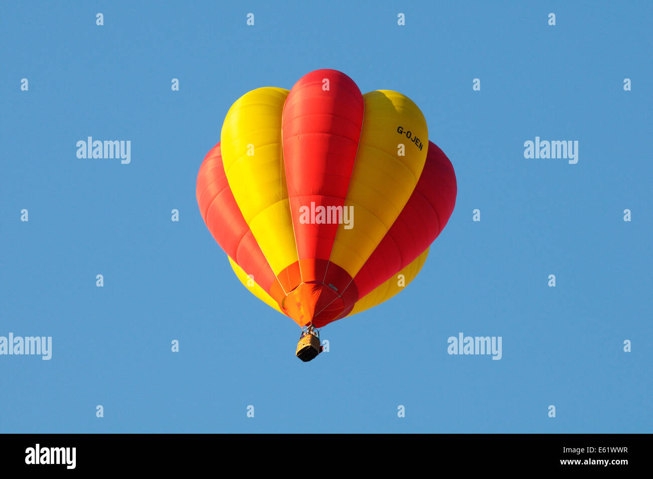 Una colorata mongolfiera in volo con cielo blu dietro durante il Bristol Balloon Fiesta si tiene annualmente Foto Stock