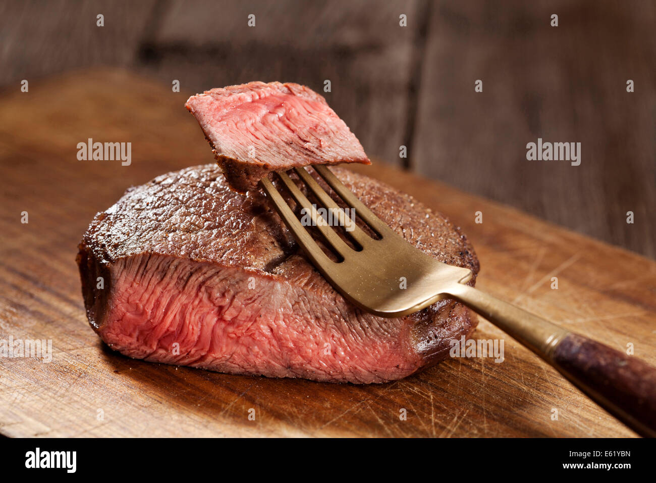 Bistecca di manzo cotta per mezzo raro su sfondo di legno Foto Stock