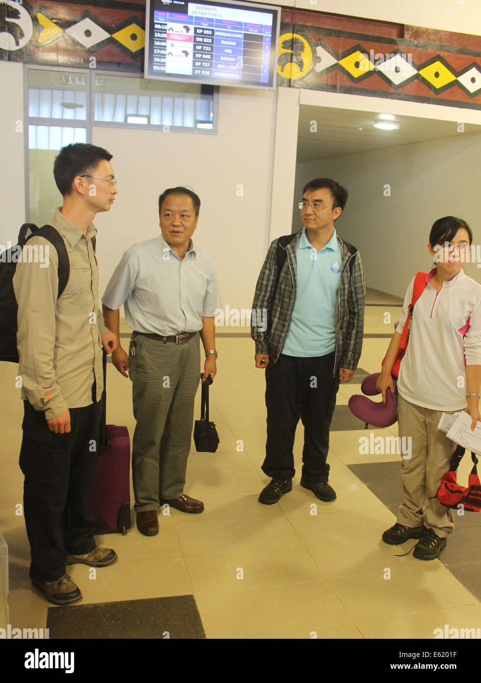 Conakry. 11 Ago, 2014. Tre malattie cinese esperti di controllo (1L, 2R e 1R) arrivano all'aeroporto di Conakry, capitale della Guinea, 11 Agosto, 2014. La Nazionale Cinese per la salute e la pianificazione familiare Commissione (NHFPC) ha annunciato il Sabato che la Cina avrebbe inviato tre squadre di esperti e di forniture mediche per la Guinea, la Liberia e la Sierra Leone per aiutare la prevenzione e il controllo del virus Ebola. Credito: Xinhua/Alamy Live News Foto Stock