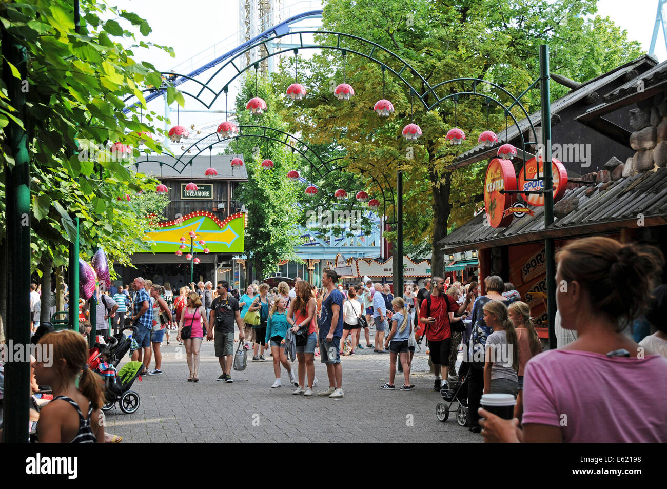 La gente camminare sotto le montagne russe a Grona Lund parco divertimenti a Stoccolma in Svezia. Tivoli Gröna Lund (lit. Il boschetto di verde) Foto Stock