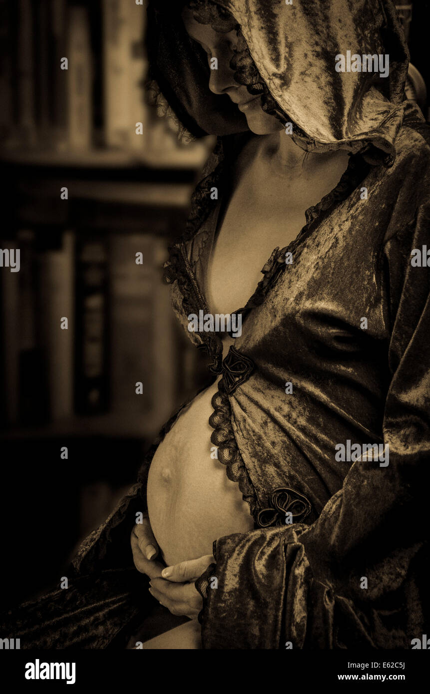 Donna incinta in seta abito con cappuccio Foto Stock