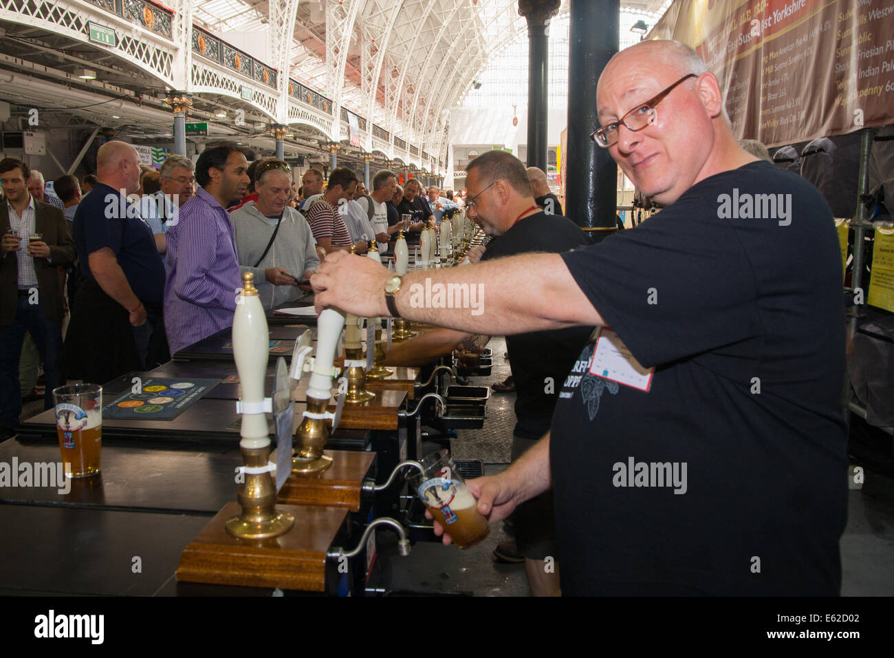 Olympia, Londra, Regno Unito. 12 Ago, 2014. Brisk business è fatto a pompe come centinaia di persone campione 900 diverse autentiche birre, birre internazionali, sidri e perries presso la camra Great British Beer Festival. Credito: Paolo Davey/Alamy Live News Foto Stock