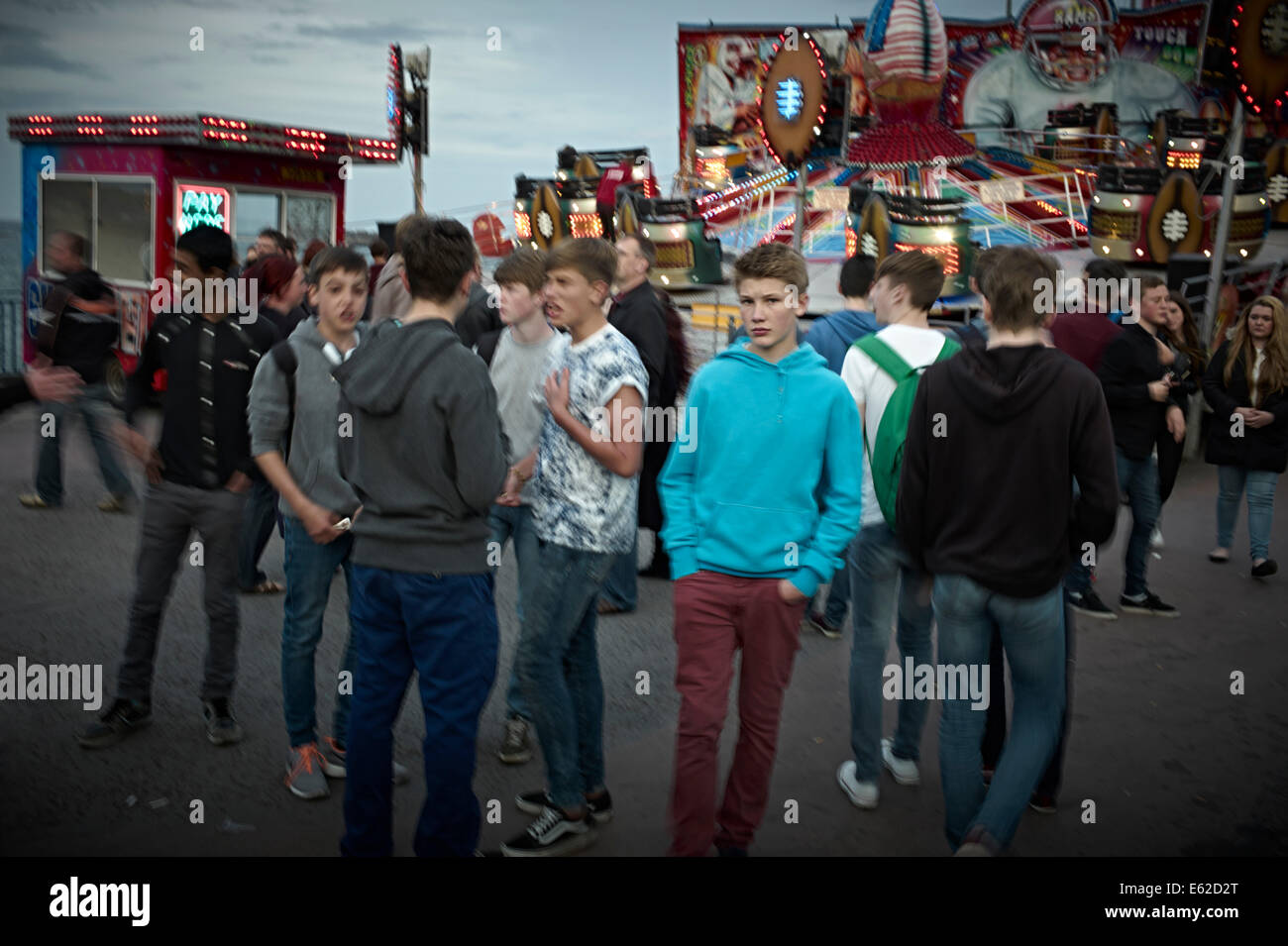 Ragazzi adolescenti come un gruppo in un luna park con uno che guarda in telecamera Foto Stock