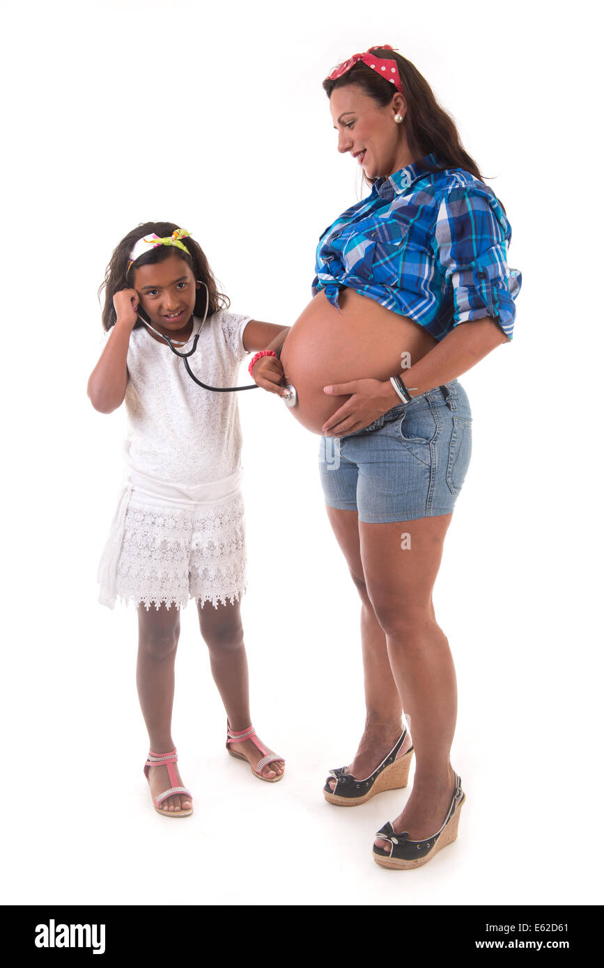 Ragazza giovane ascoltando la sua gravidanza madre ventre Foto Stock