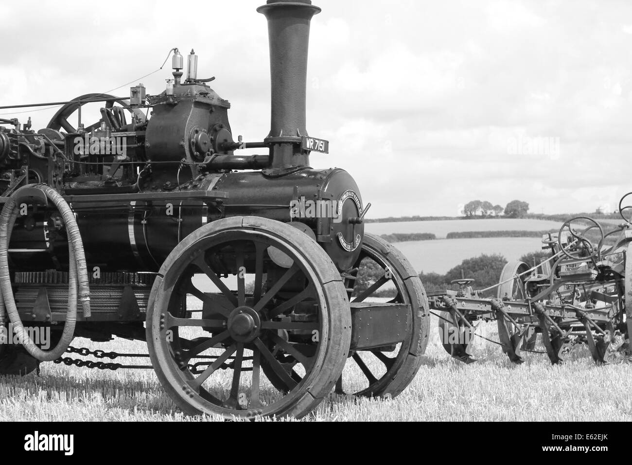 Un trattore a vapore tirando un aratro in bianco e nero Foto Stock