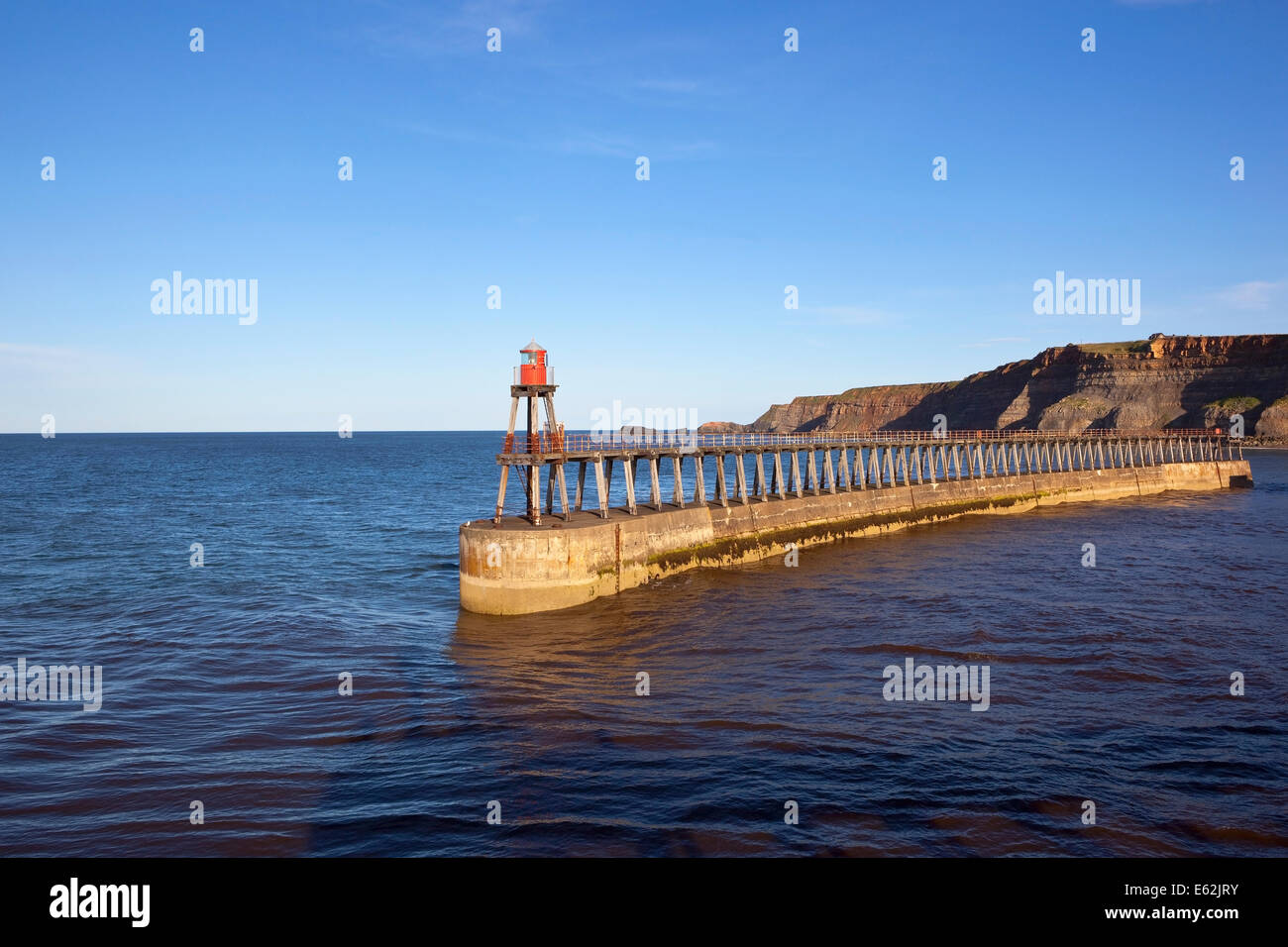 Il sud del molo del porto di Whitby e scogliere affacciate sul Mare del Nord su Yorkshire East coast. Foto Stock