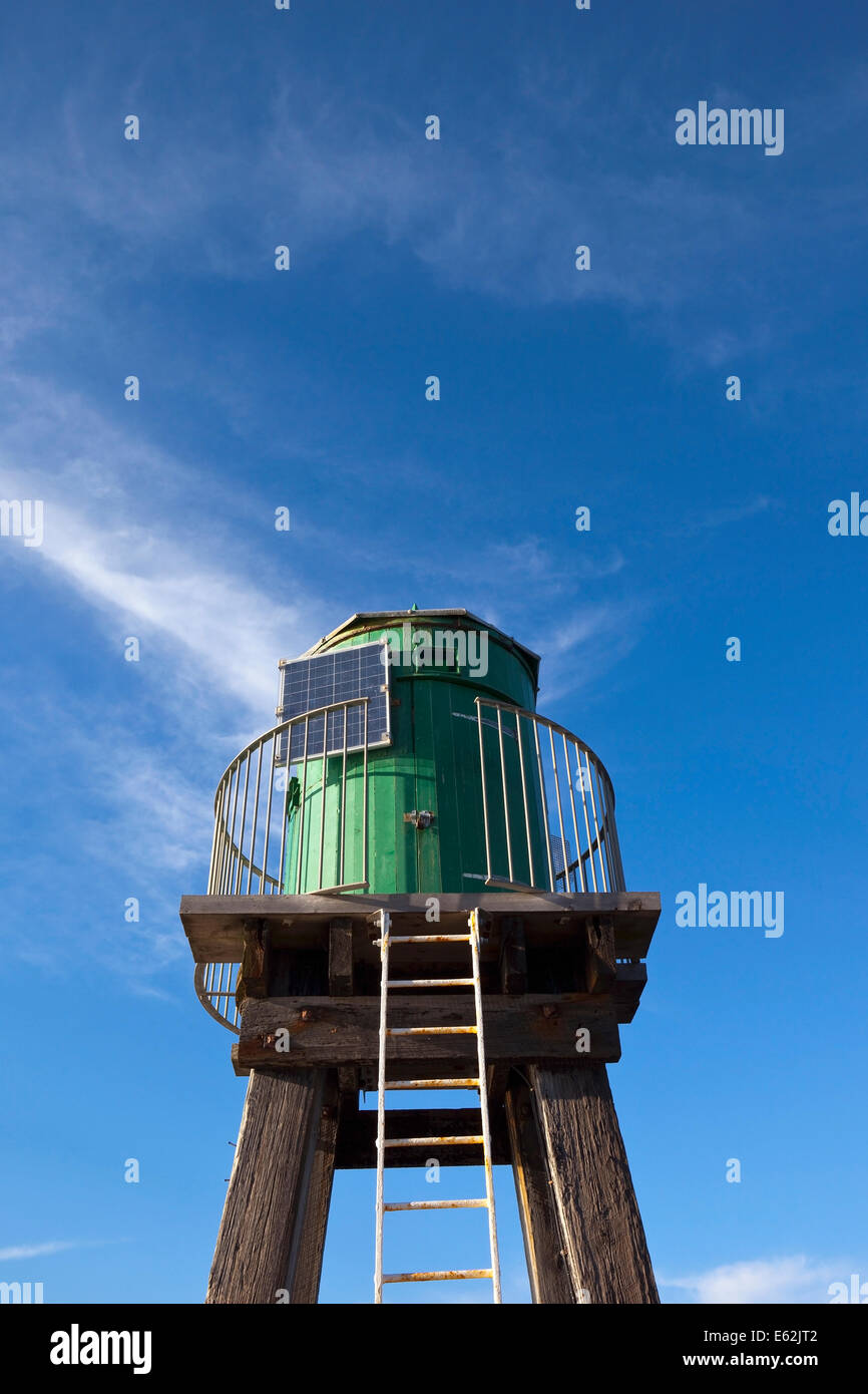 Il legno torre faro equipaggiato con un pannello solare a Whitby porto sotto un cielo di estate blu. Foto Stock