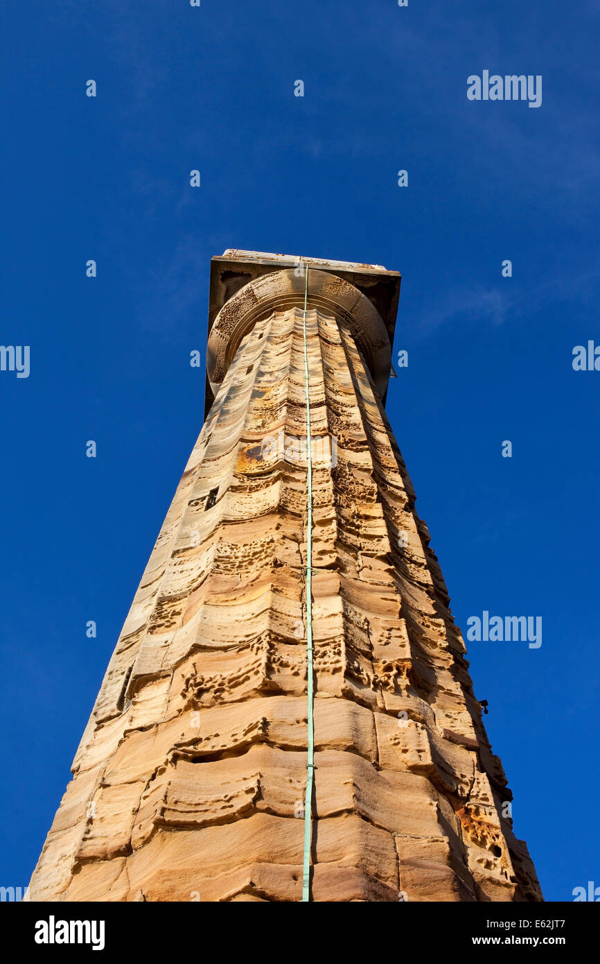 Il vecchio weathered stone torre faro con rame parafulmine a Whitby porto sotto un cielo di estate blu. Foto Stock