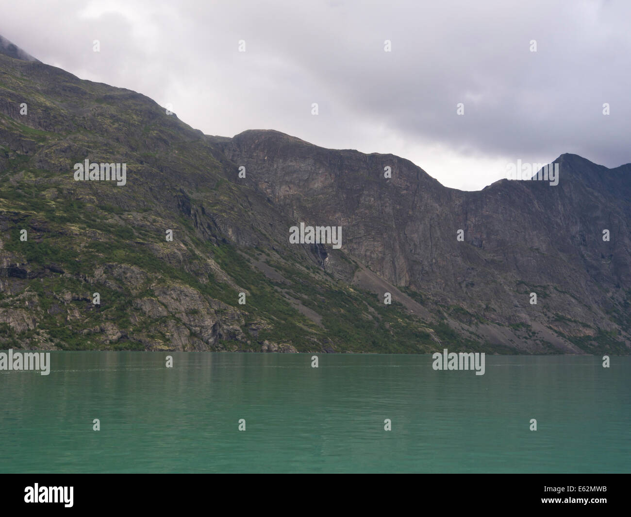 Lago Gjende in Jotunheimen Norvegia, praticamente un fiordo di montagna con ripidi fianchi, la famosa passeggiata Besseggen corre lungo la parte superiore Foto Stock