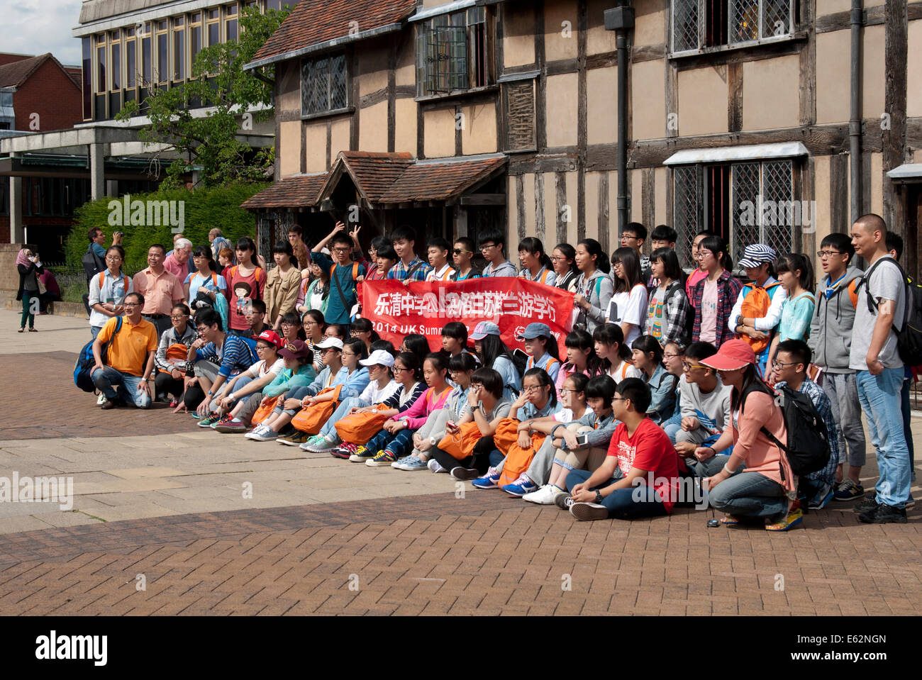 Cinese turisti adolescenti schierate per una fotografia, Stratford-upon-Avon, Regno Unito Foto Stock