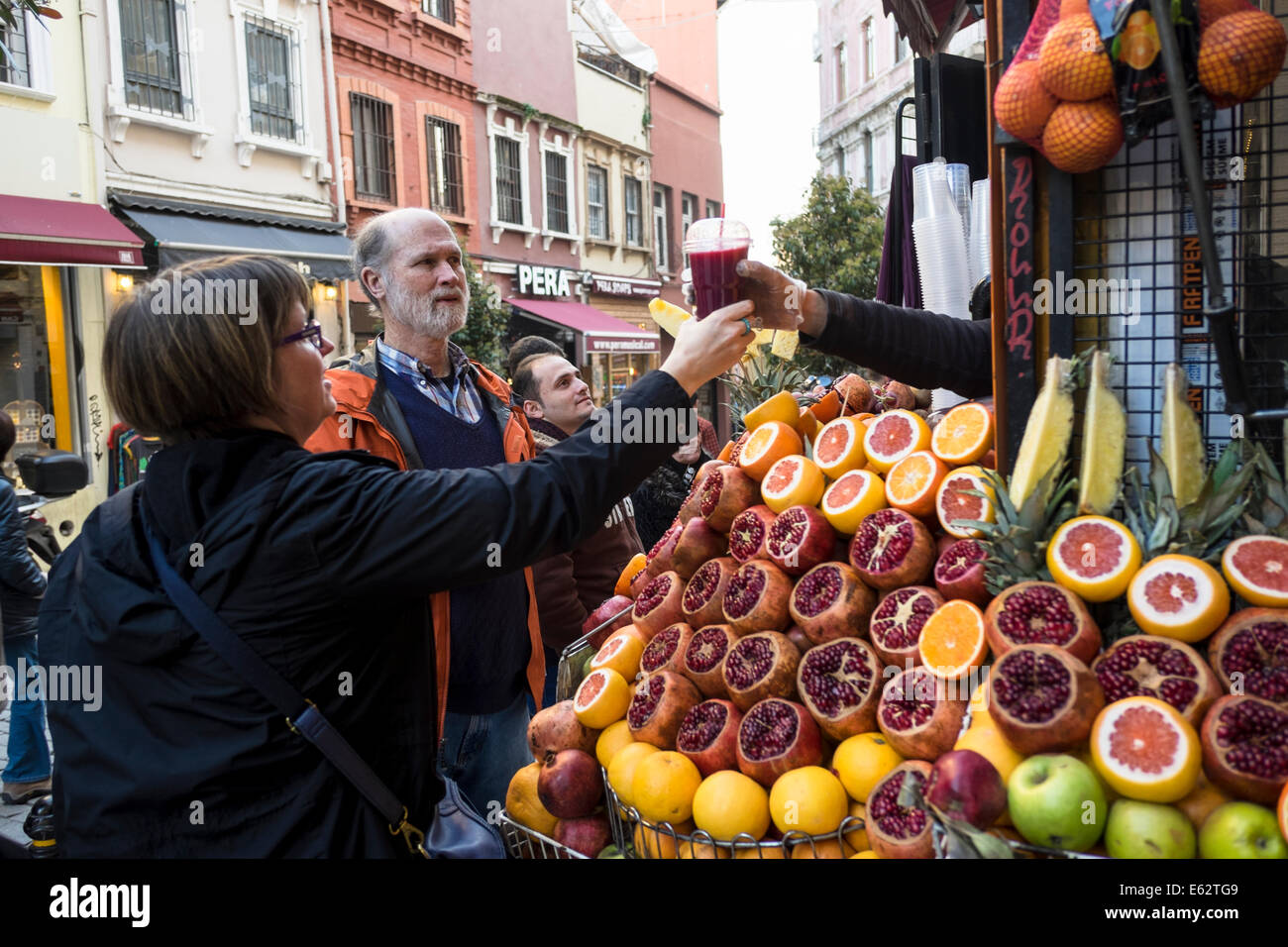 Una donna acquista una melagrana succo di frutta fresco ad Istanbul in Turchia nel marzo 2014. Foto Stock