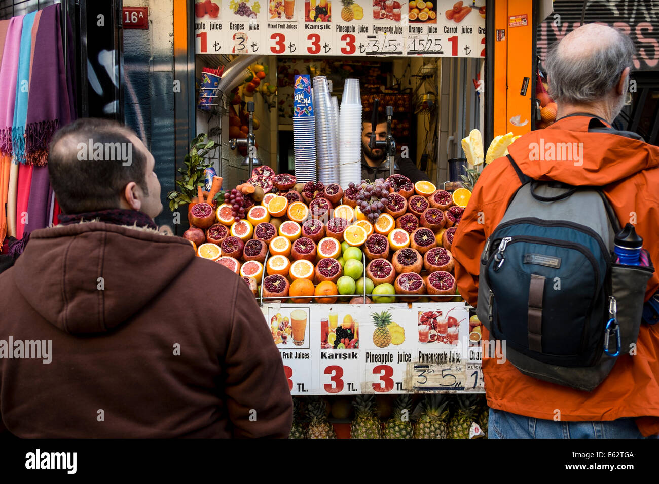 I clienti attendono nella parte anteriore di un succo di frutta fresco venditore ad Istanbul in Turchia nel marzo 2014. Foto Stock