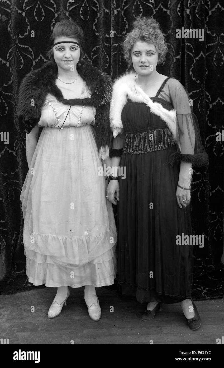 1900s 1910s due donne in piedi a fianco a fianco di indossare abiti eleganti guardando la telecamera SILENT MOVIE ANCORA Foto Stock