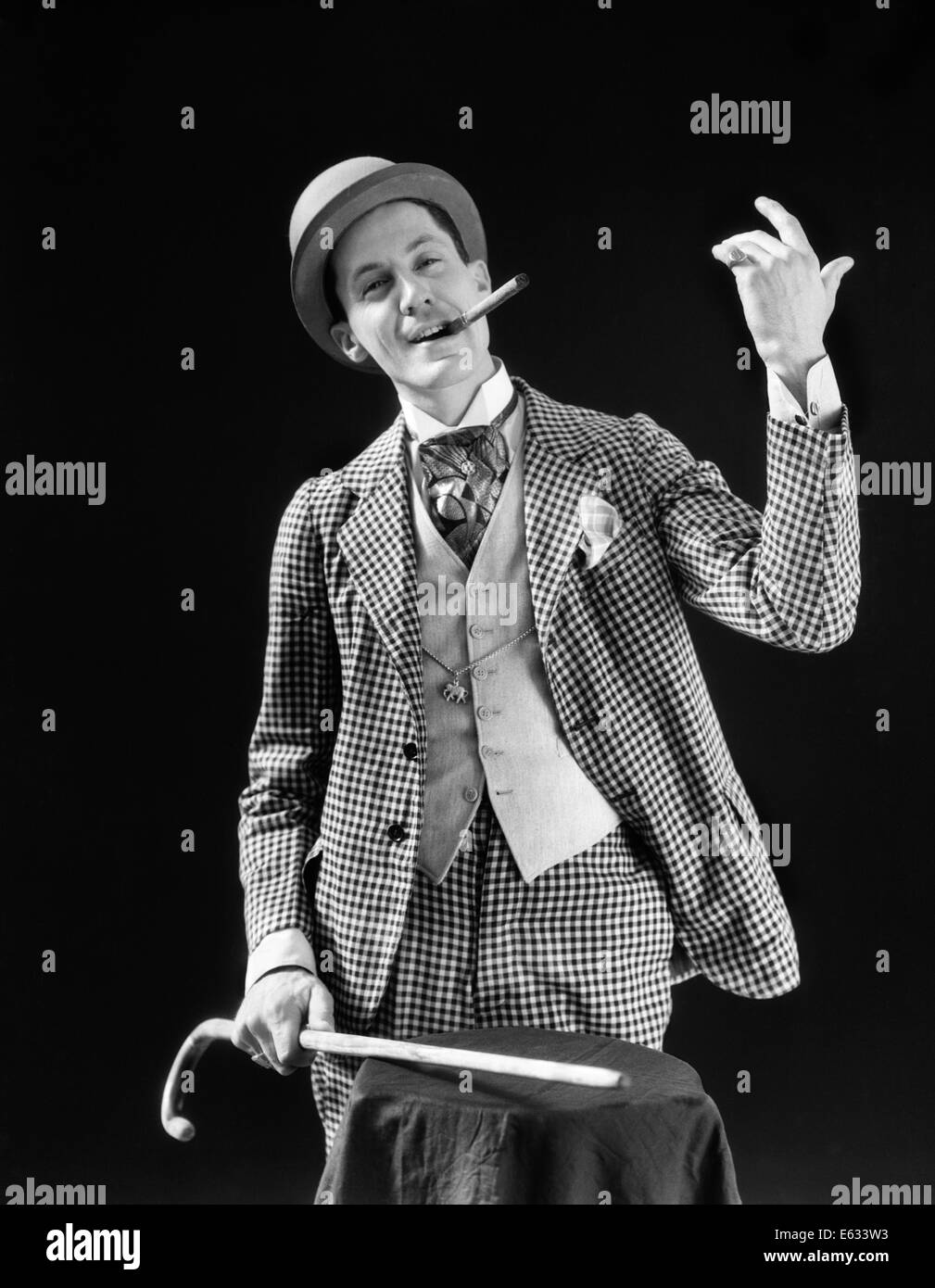 1910s 1920s CON CARATTERE UOMO BARKER Bowler cappello LOUD VAUDEVILLE TIPO VESTITI tenendo la canna da zucchero fumatori di sigaro GIOCO DI FIDUCIA Foto Stock