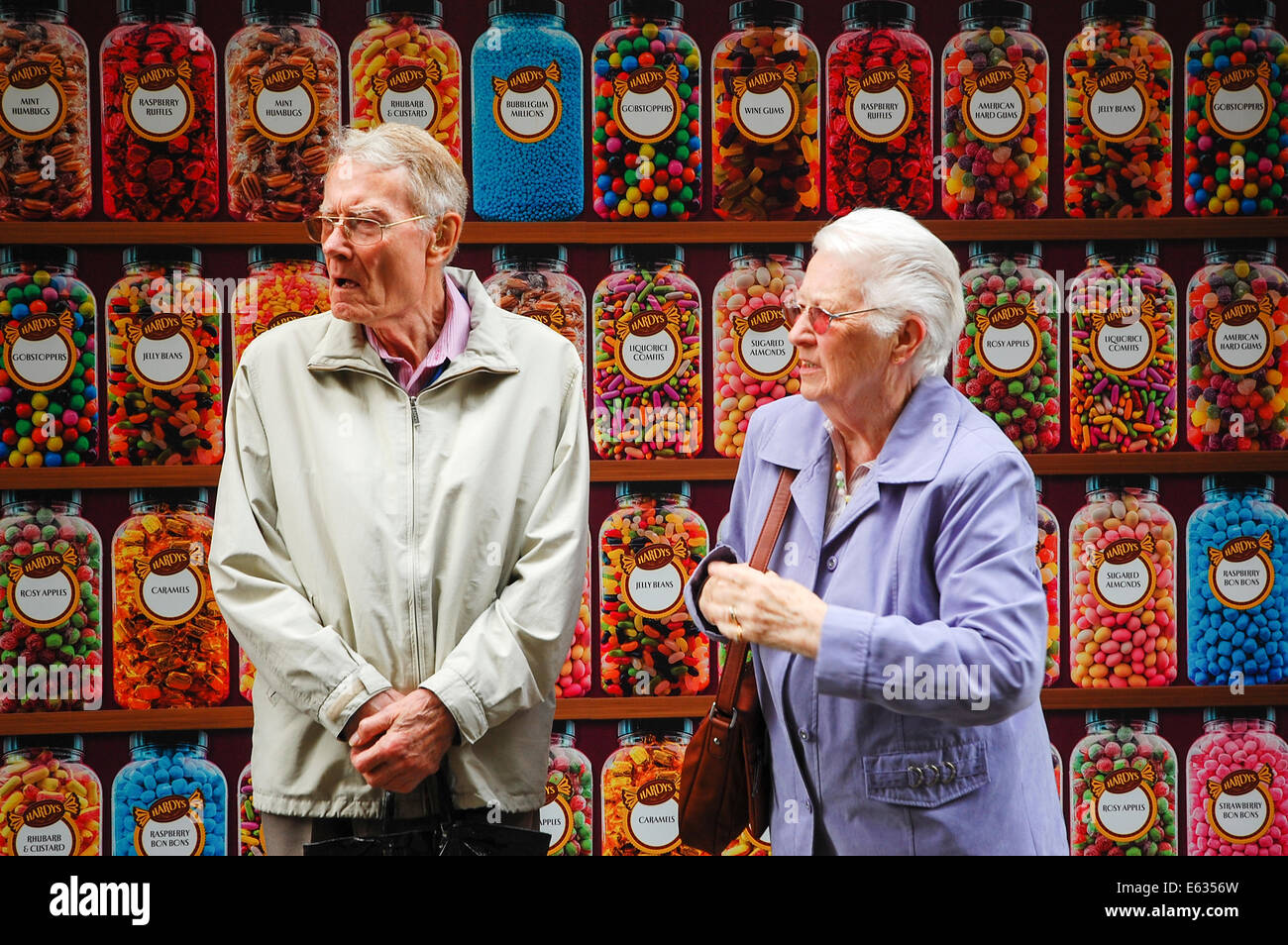 Due anziani in piedi al di fuori di un negozio di dolci Foto Stock
