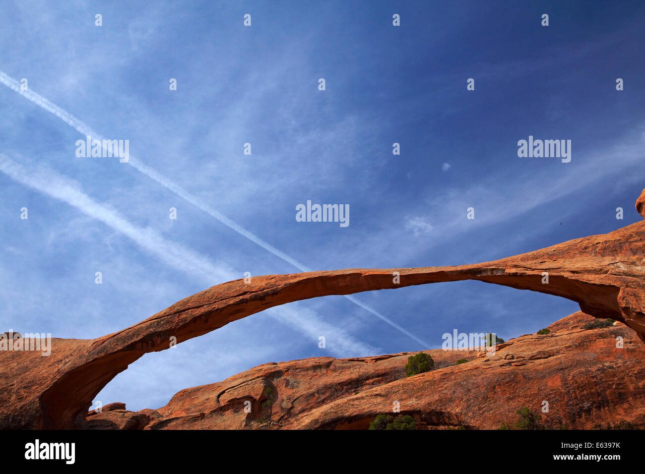 Landscape Arch (più lunga del mondo naturale di roccia ad arco), e jet contrails, Giardino del Diavolo area del Parco Nazionale di Arches, vicino a Moab, U Foto Stock