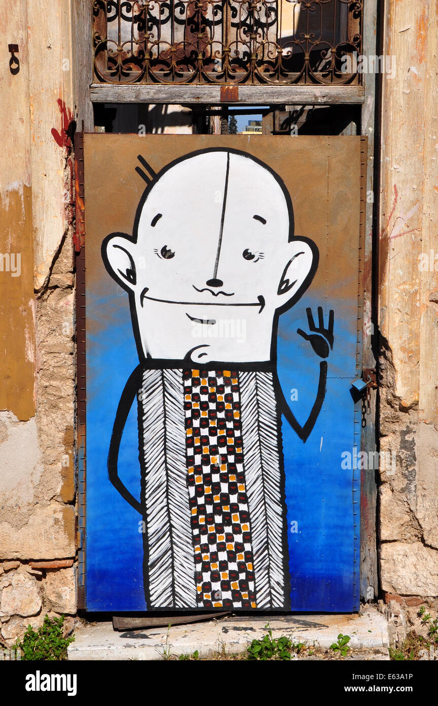 Divertente personaggio dei fumetti abstract graffiti sul intavolato porta di una casa abbandonata. Foto Stock