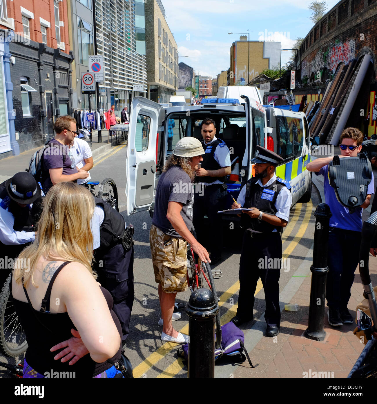 Supporto di polizia ufficiali bicicletta registrazione dei numeri di serie per aiutare a combattere la criminalità del ciclo in Shoreditch, London, England, Regno Unito Foto Stock