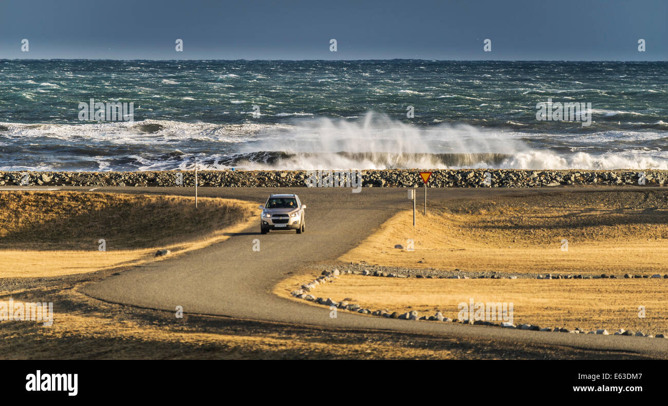 Auto sulla strada, con l'oceano sullo sfondo, vicino a Jokulsarlon (laguna glaciale), Islanda Foto Stock