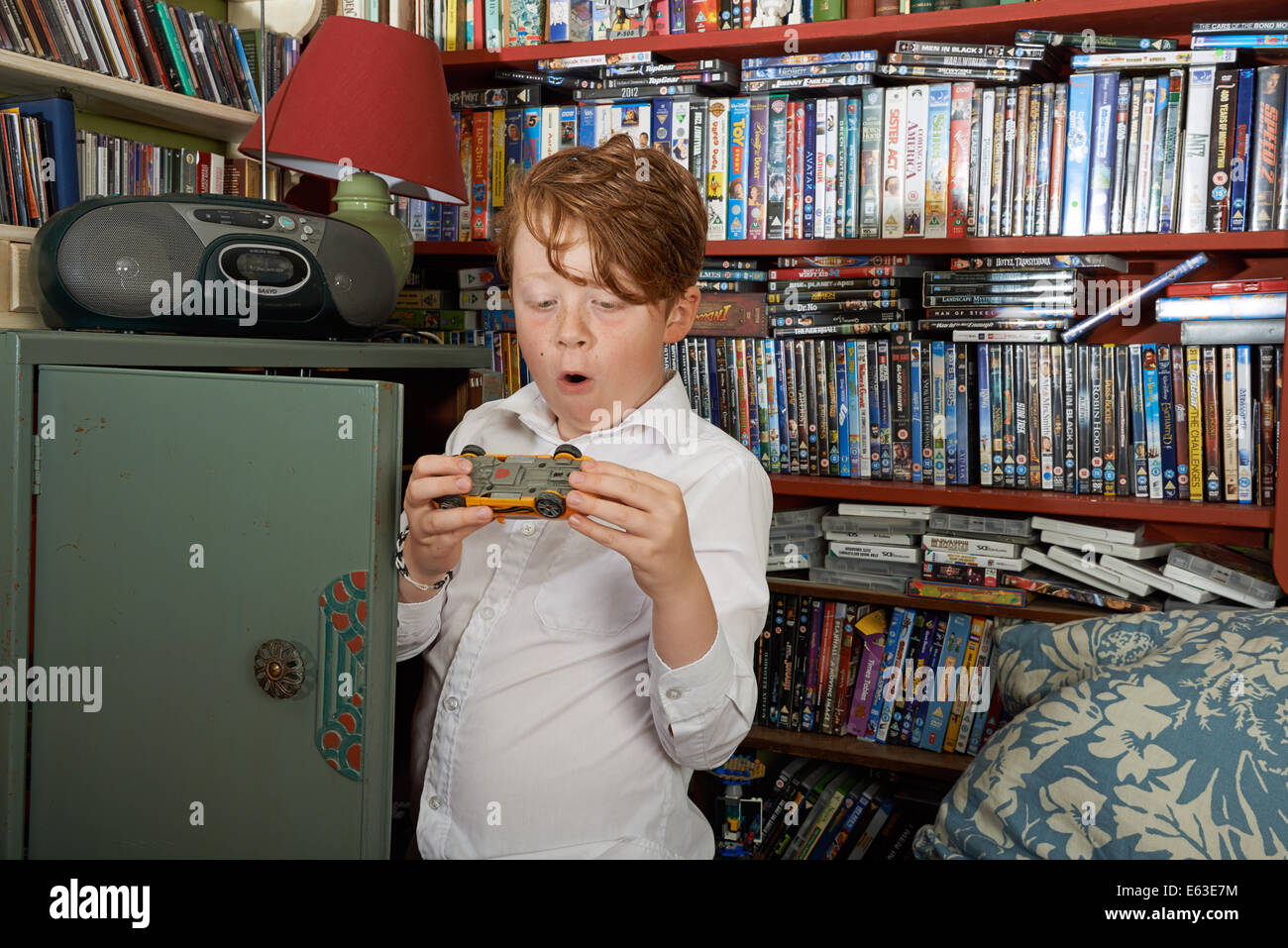 9 anno di old boy a casa dopo la scuola a giocare con una macchina giocattolo Foto Stock