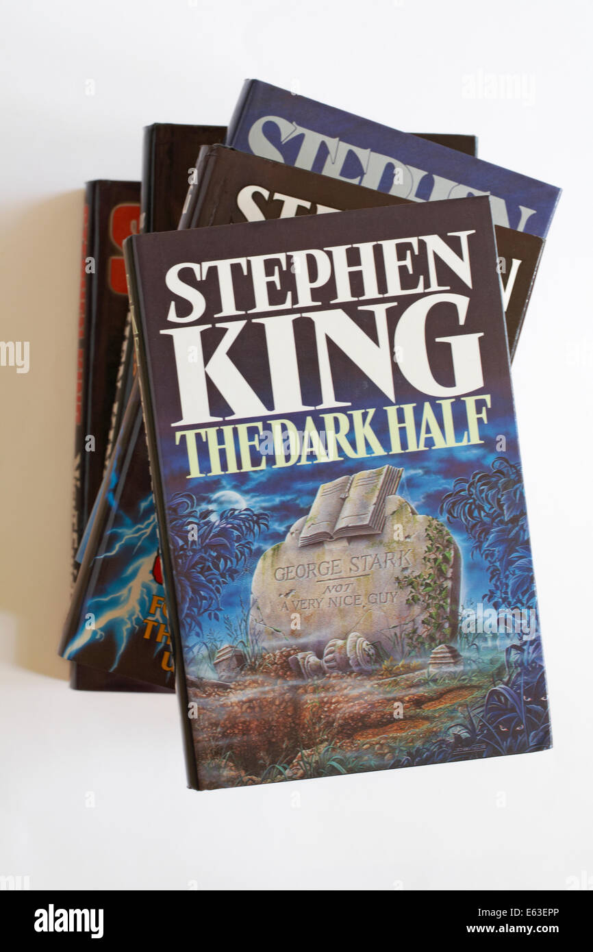 Pila di Stephen King libri con la metà scura da Stephen King in alto isolato su sfondo bianco Foto Stock