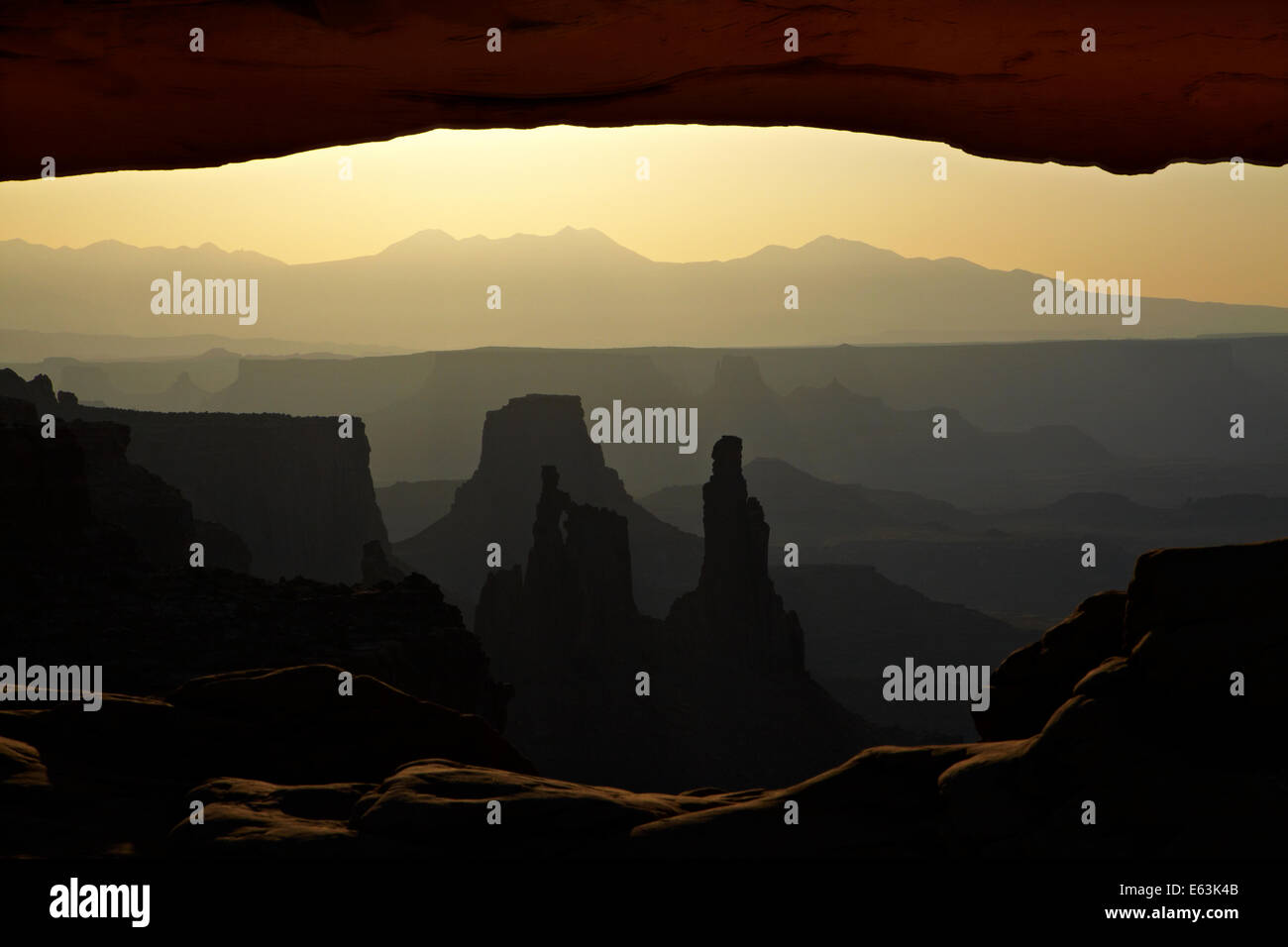 Sunrise oltre La Sal Mountains, Rondella donna Arch, e sotto Mesa Arch, il Parco Nazionale di Canyonlands, Utah, Stati Uniti d'America Foto Stock