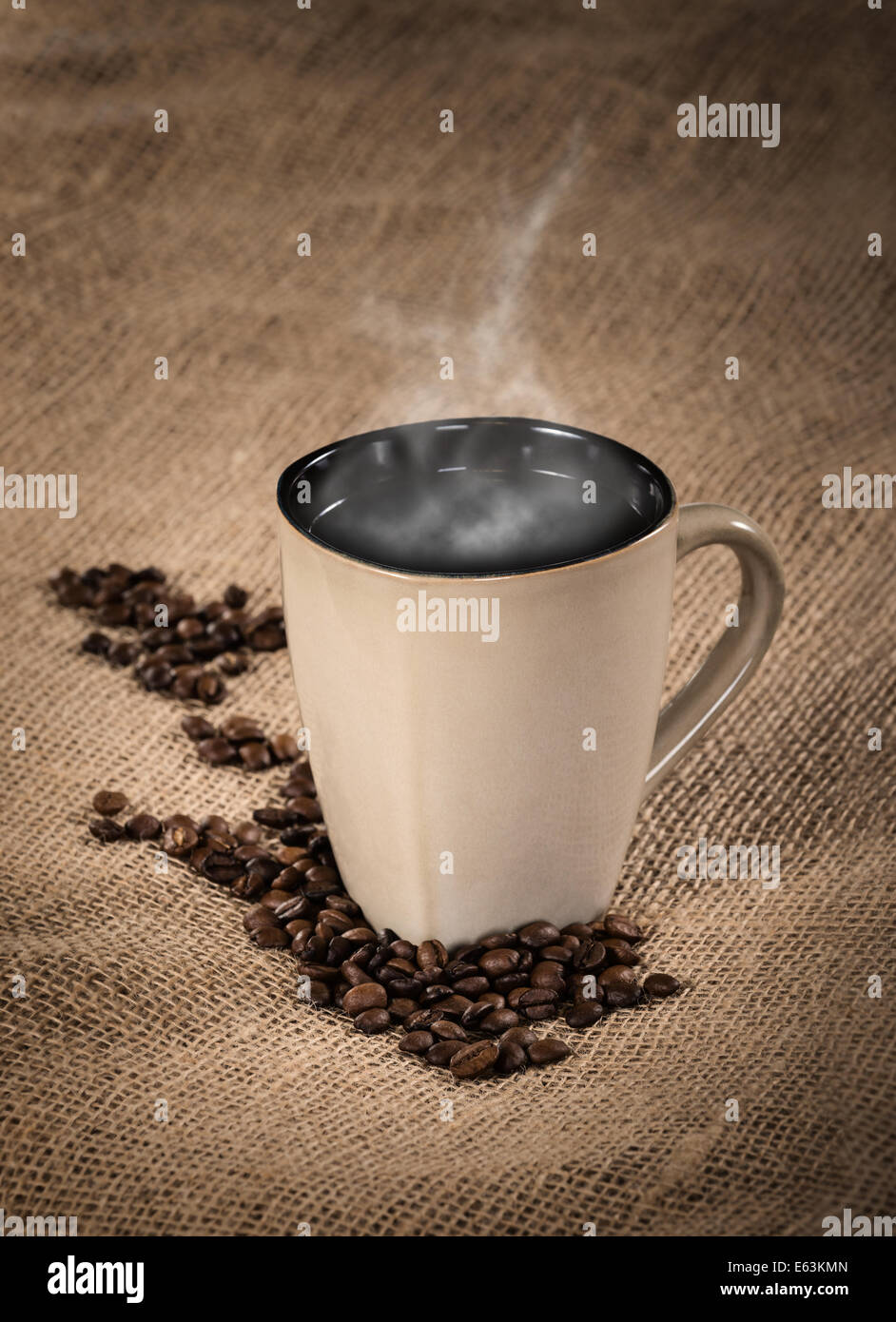Una fumante tazza di caffè nero e i chicchi di caffè su tela lo sfondo Foto Stock