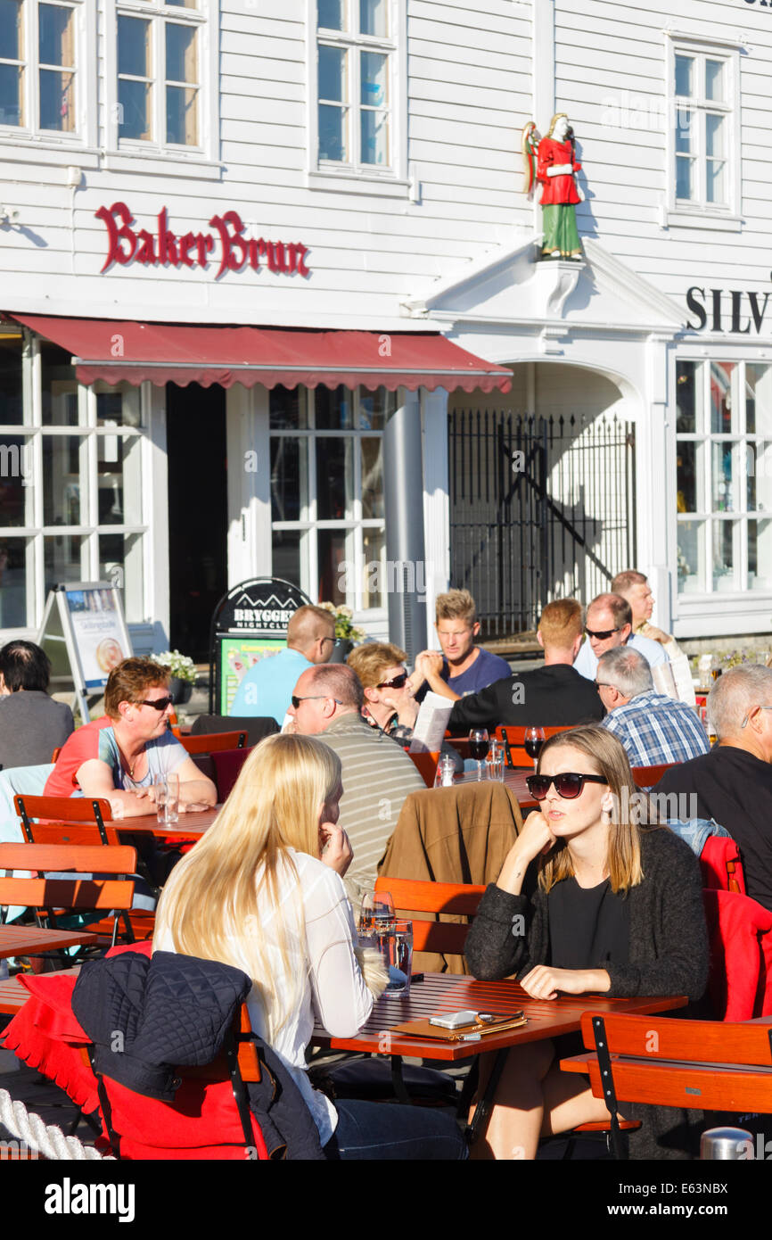 La gente seduta a terrazze all'aperto del pub a Bryggen wharf, Bergen, Norvegia Foto Stock