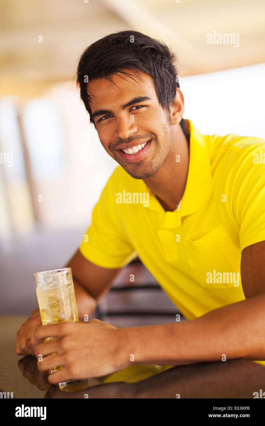 Buona ricerca uomo indiano con un drink presso il bar Foto Stock