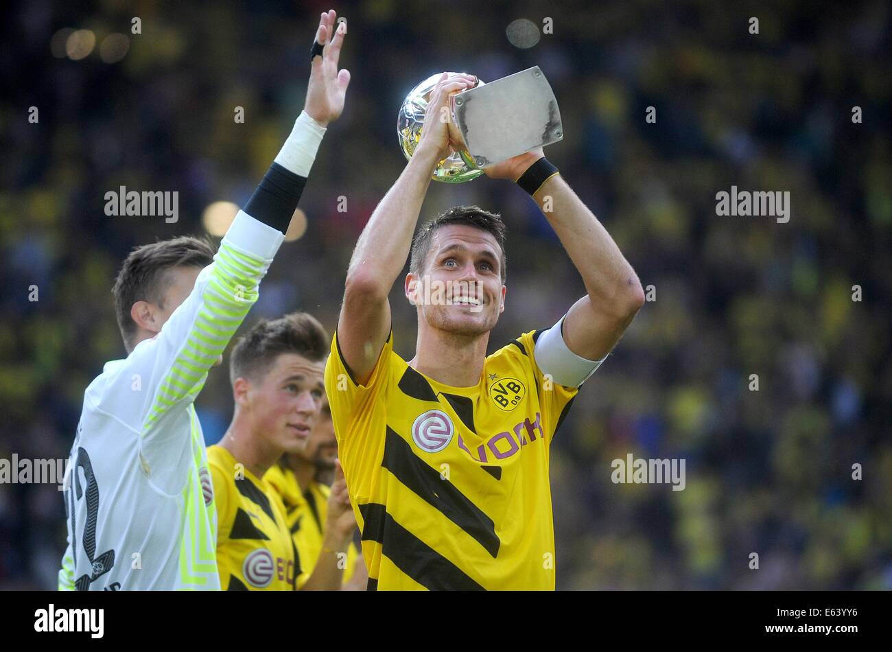 Dortmund, Germania. 13 Ago, 2014. Il Borussia Dortmund il capitano di una squadra Sebastian KEHL detiene il trofeo nelle sue mani dopo aver vinto il DFL Supercup partita di calcio contro il Bayern Monaco di Baviera al Signal Iduna Park Stadium di Dortmund, Germania, il 13 agosto 2014. Foto: Jonas Guettler/dpa t./dpa/Alamy Live News Foto Stock