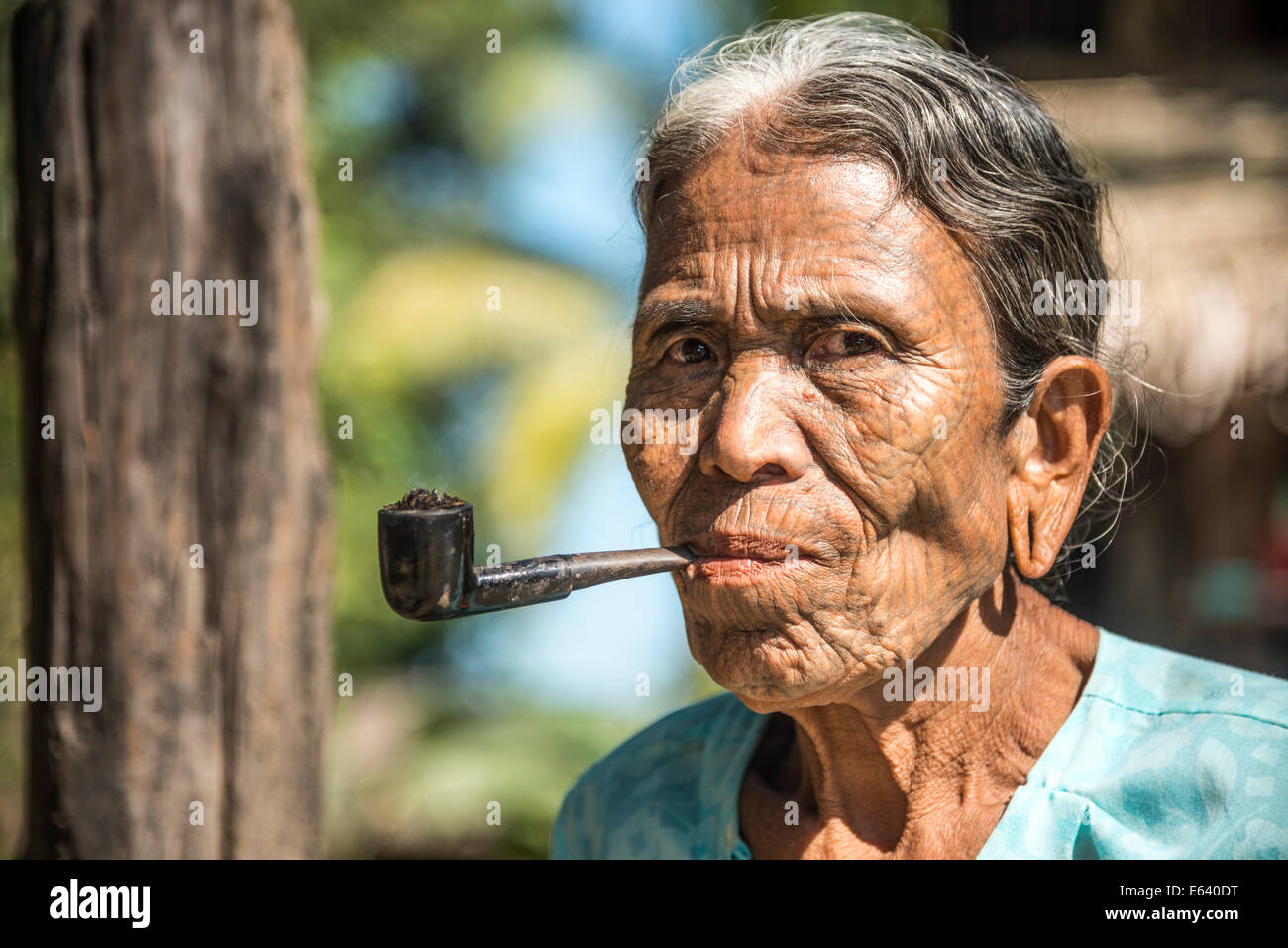 Donna del mento persone appartenenti a una minoranza etnica, con un tradizionale tatuaggi facciali di fumare un tubo, l'ultima della loro natura, ritratto Foto Stock